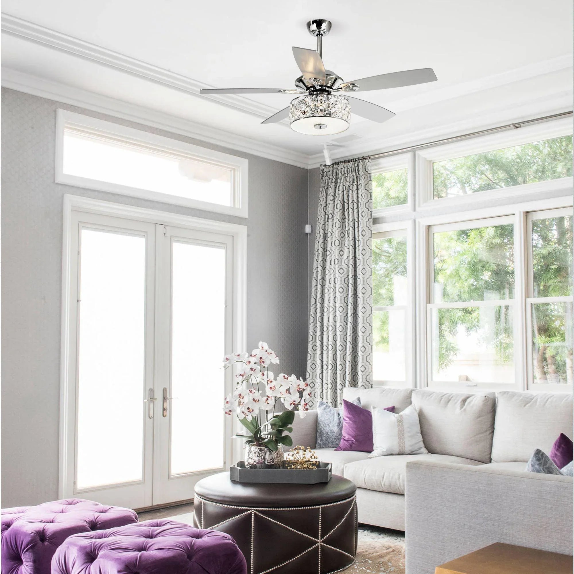 Chrome ceiling fan with crystal lamp light and silver blades in a living room