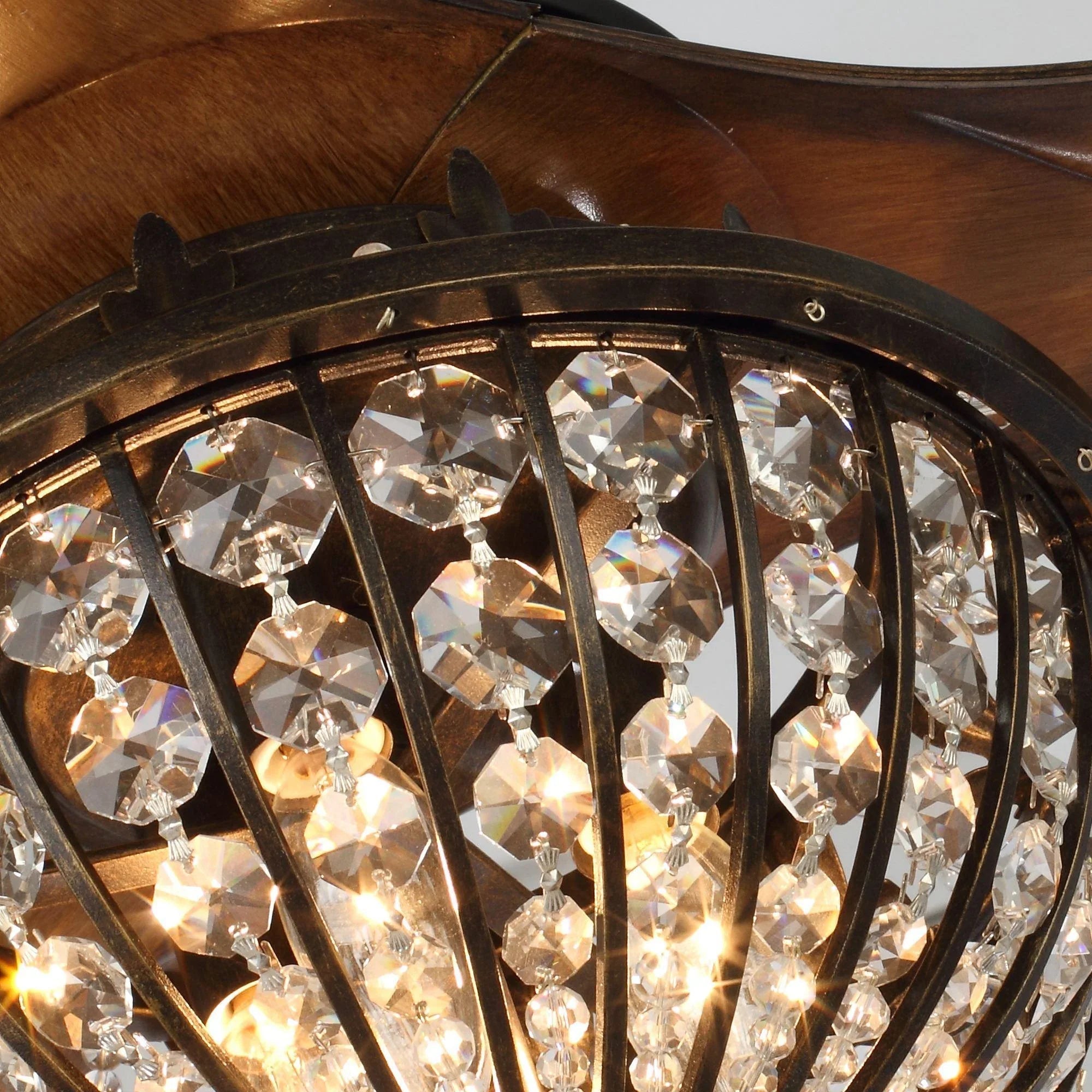 Crystal-glass ceiling fan light with warm bulbs in an ornate black metal frame