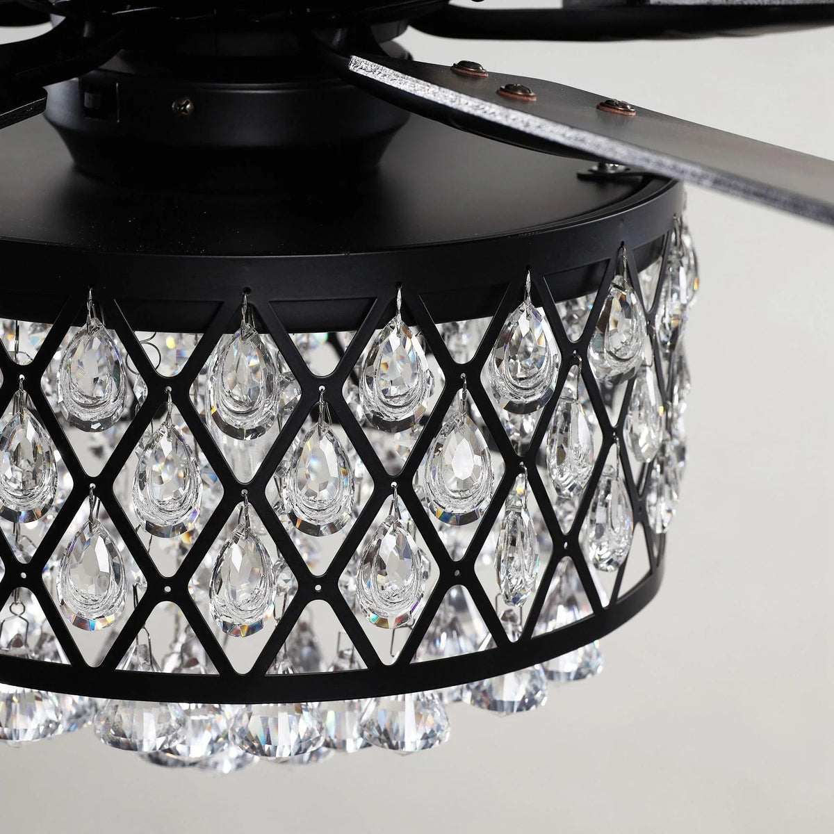 Crystal chandelier light cluster in black lattice cage under black ceiling fan
