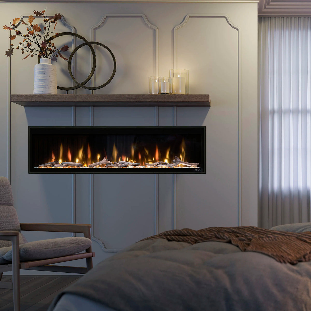 Linear electric fireplace in black frame with orange flame effect over faux logs