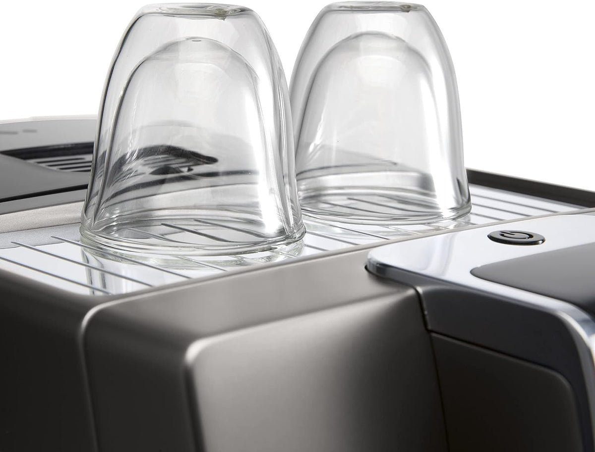 Two clear double wall latte macchiato glasses placed upside down on espresso machine tray