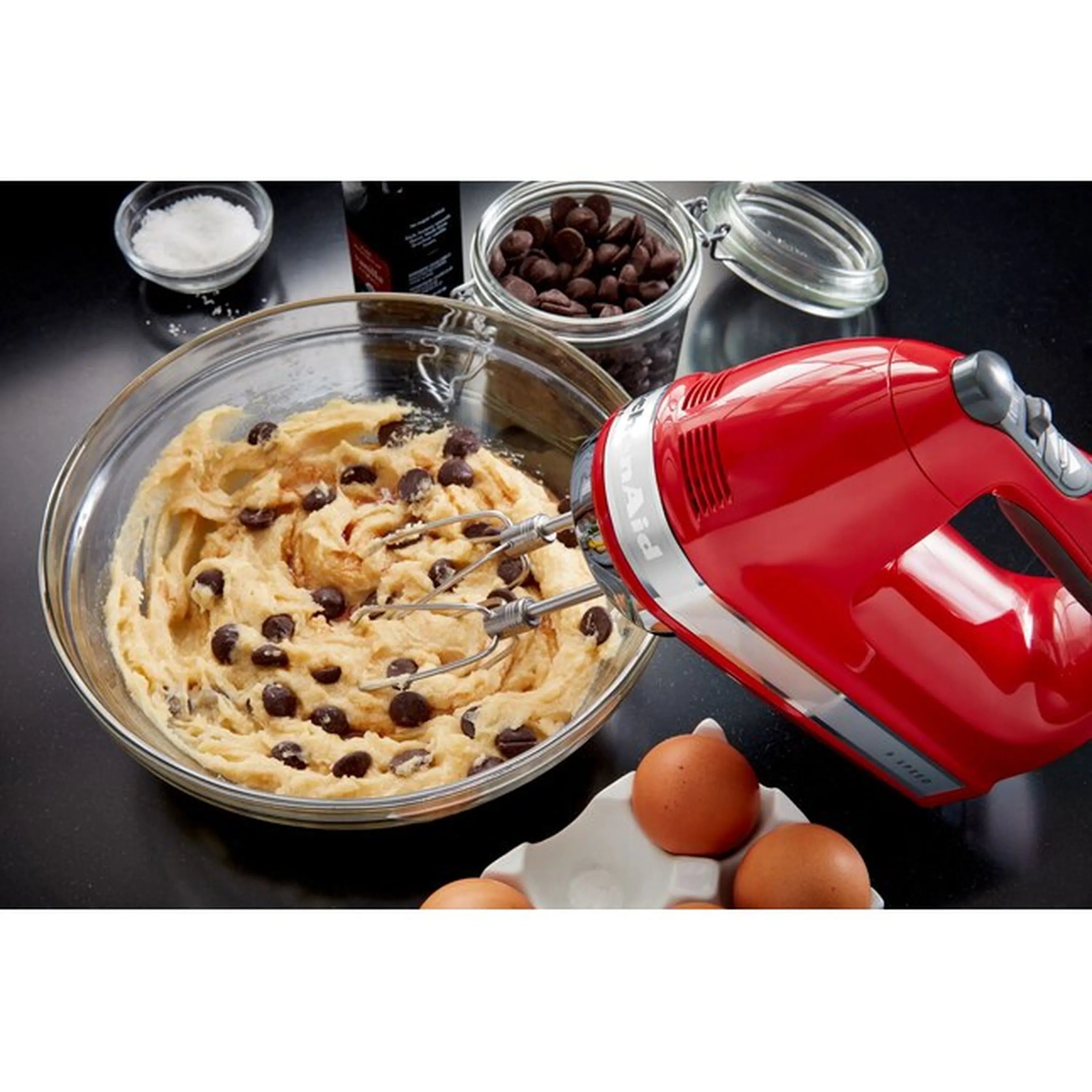 KitchenAid hand mixer mixing cookie dough with metal beaters in a bowl