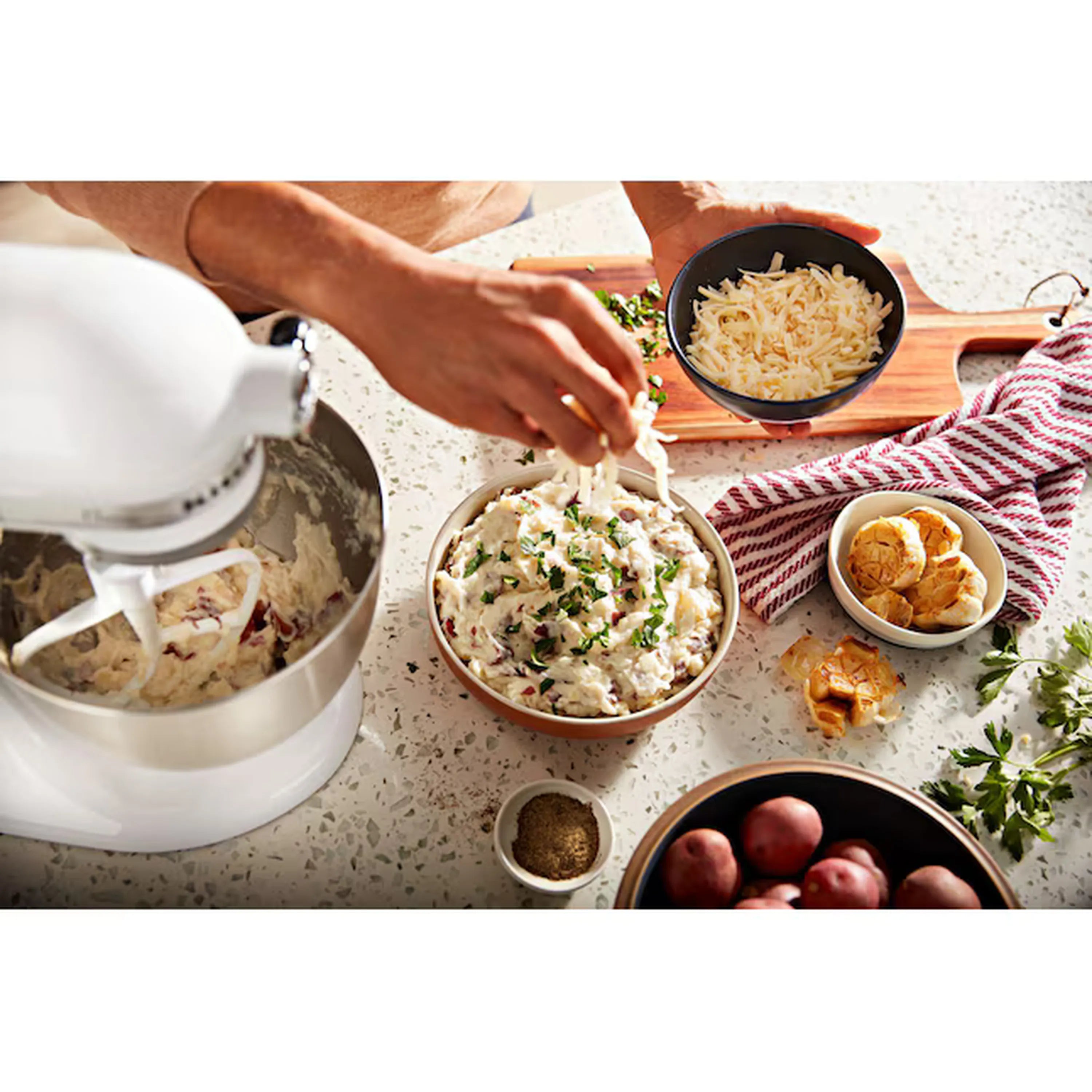 White stand mixer with stainless bowl filling batter during mixing