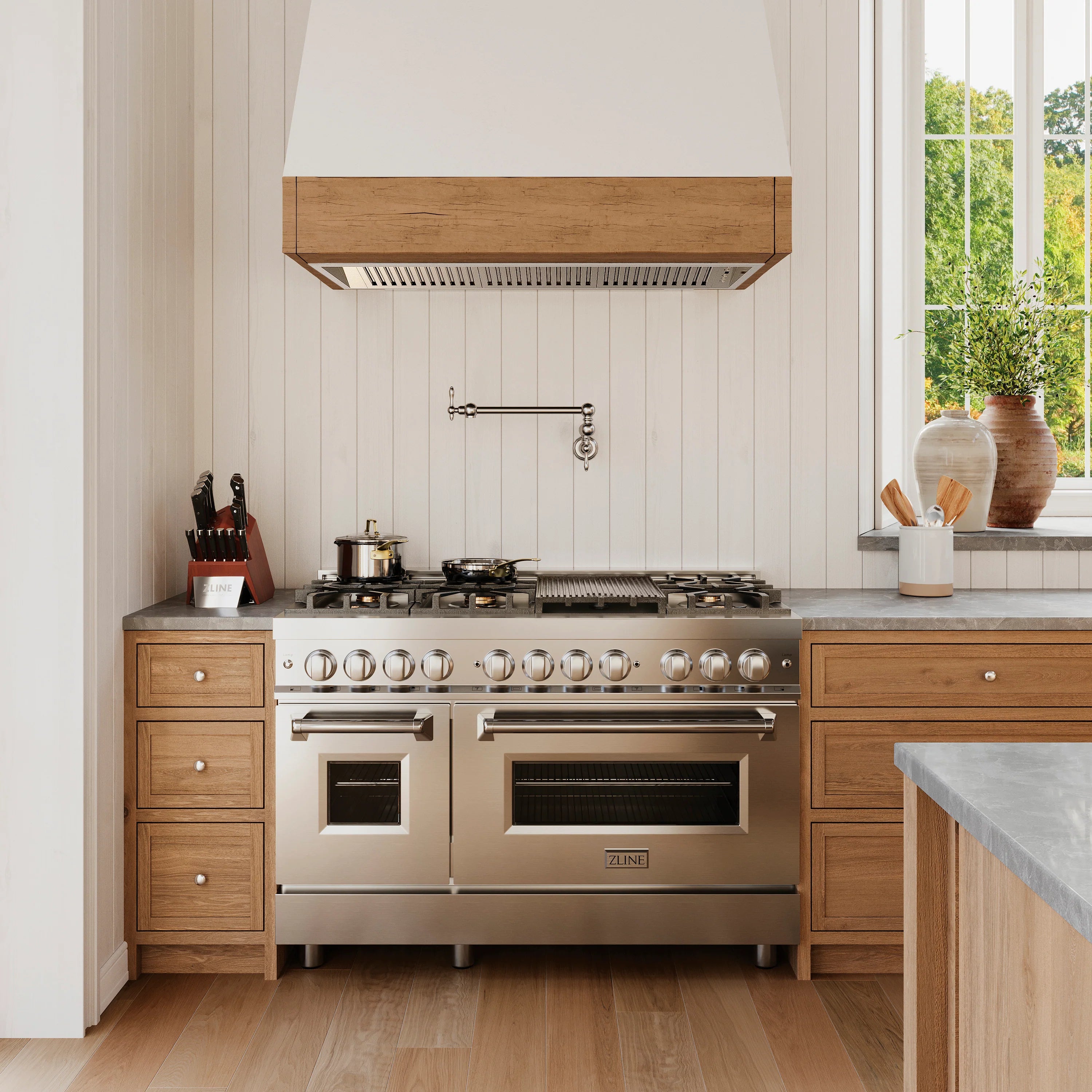 Stainless steel range hood insert installed above a gas cooktop