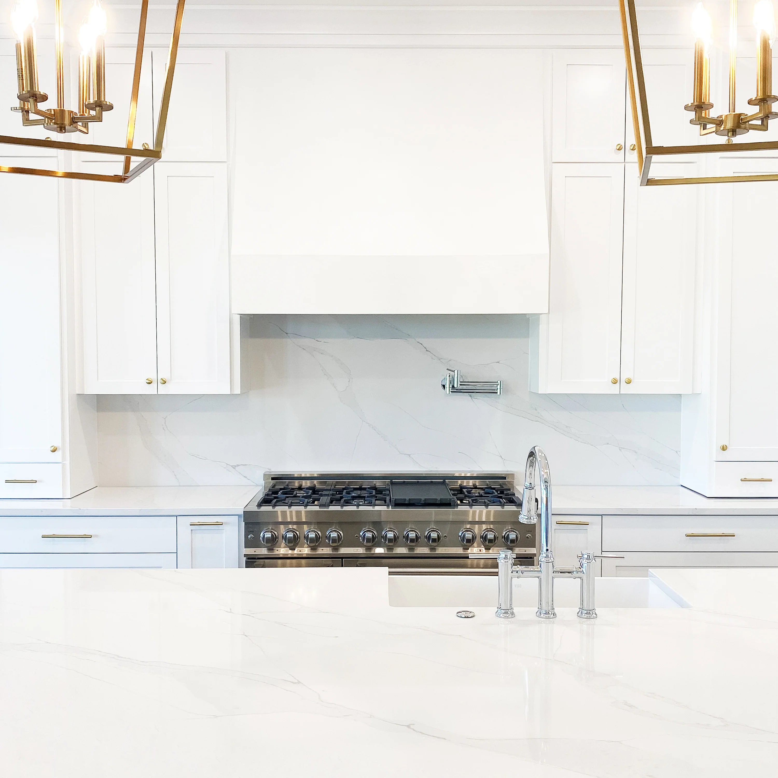 Stainless steel range hood insert installed above a gas cooktop