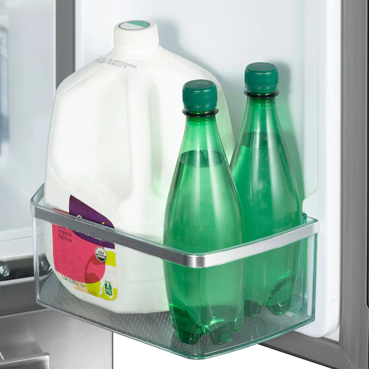 Refrigerator door shelf with clear bin holding two green glass bottles and a white jug