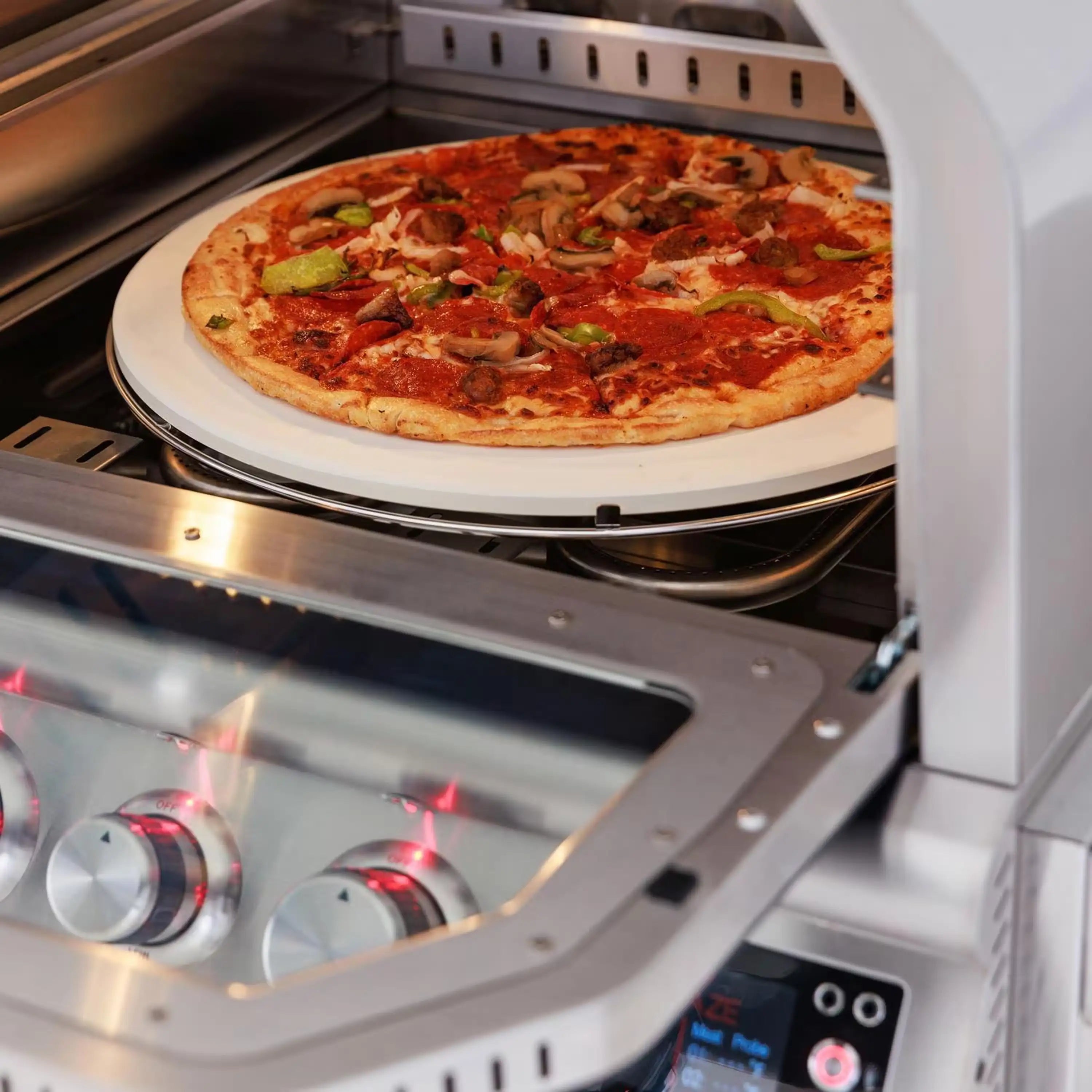 Open outdoor pizza oven showing a veggie-topped pizza on the round stone