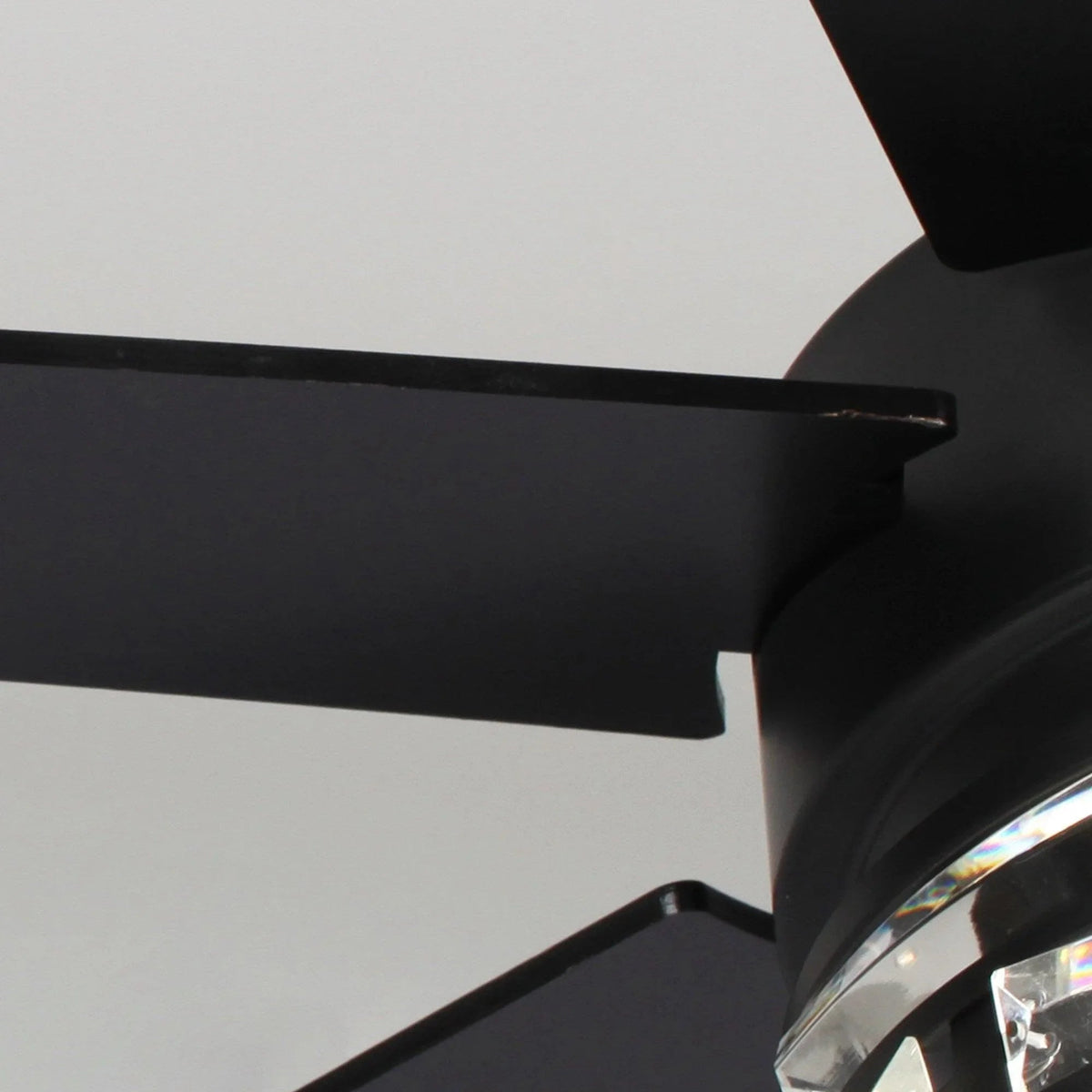 Black ceiling fan blade and motor housing with clear light panels detail