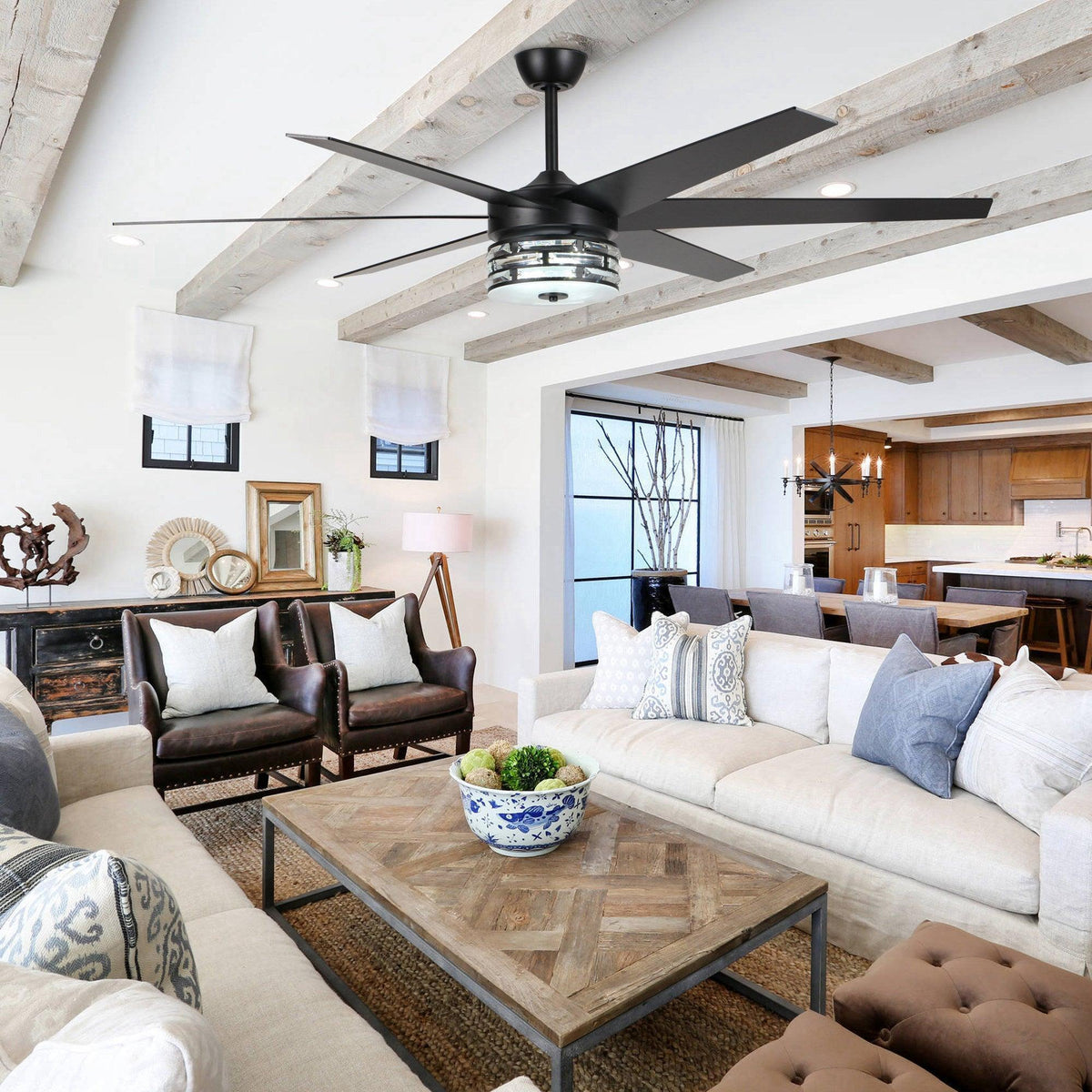Black ceiling fan with long blades and clear glass light housing in living room