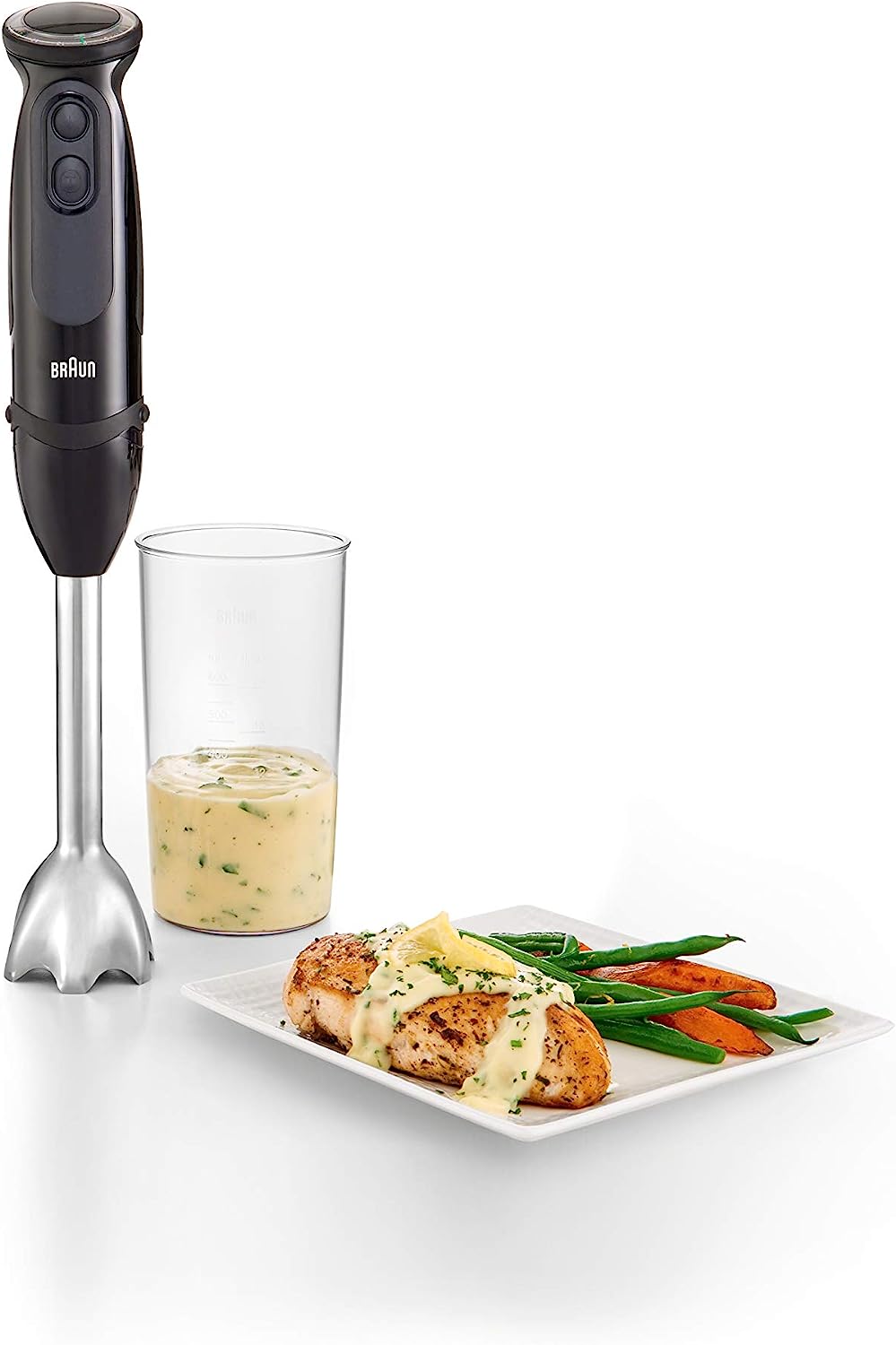 Braun hand blender with blending cup and food tray beside it