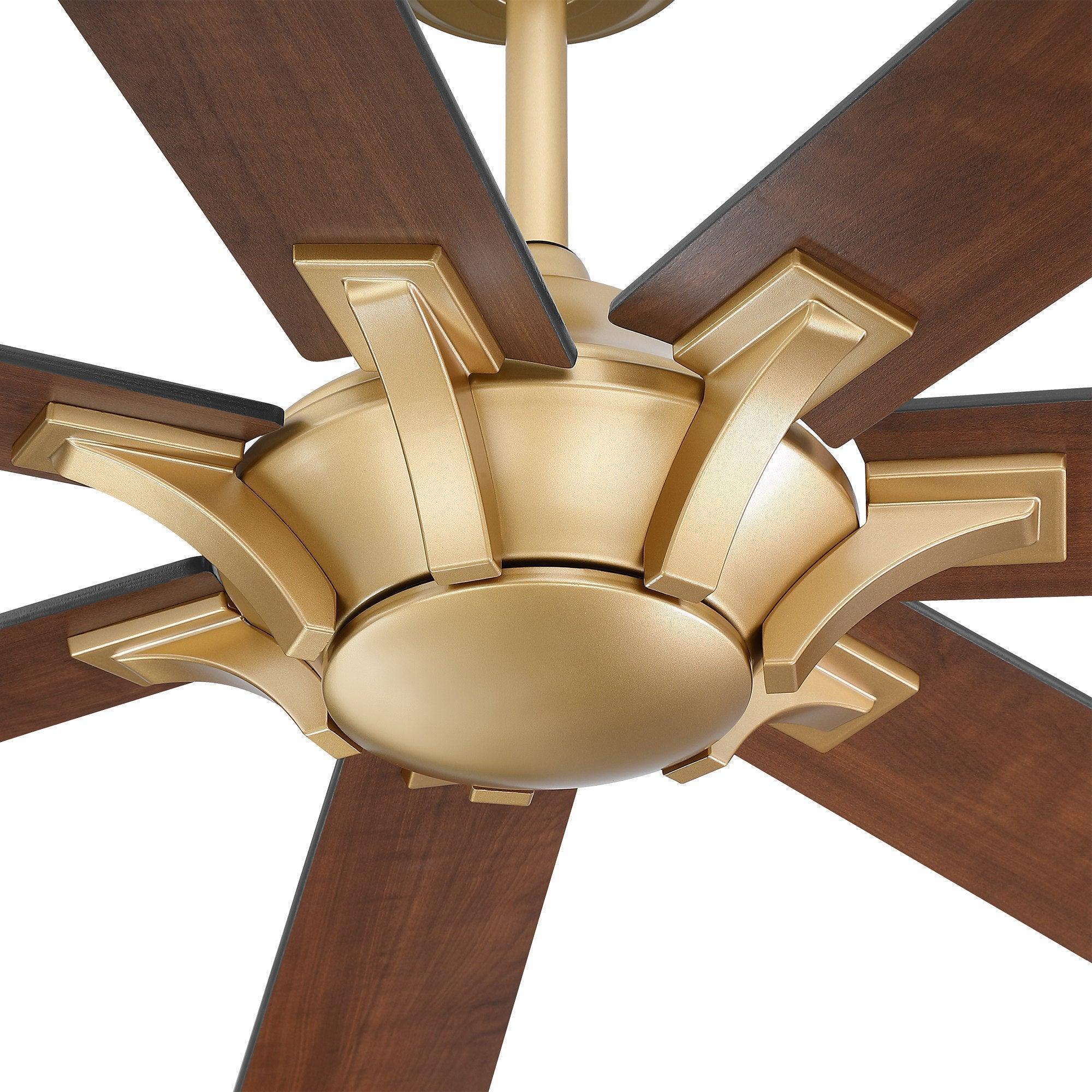 Close-up of golden ceiling fan motor housing with five wood blades