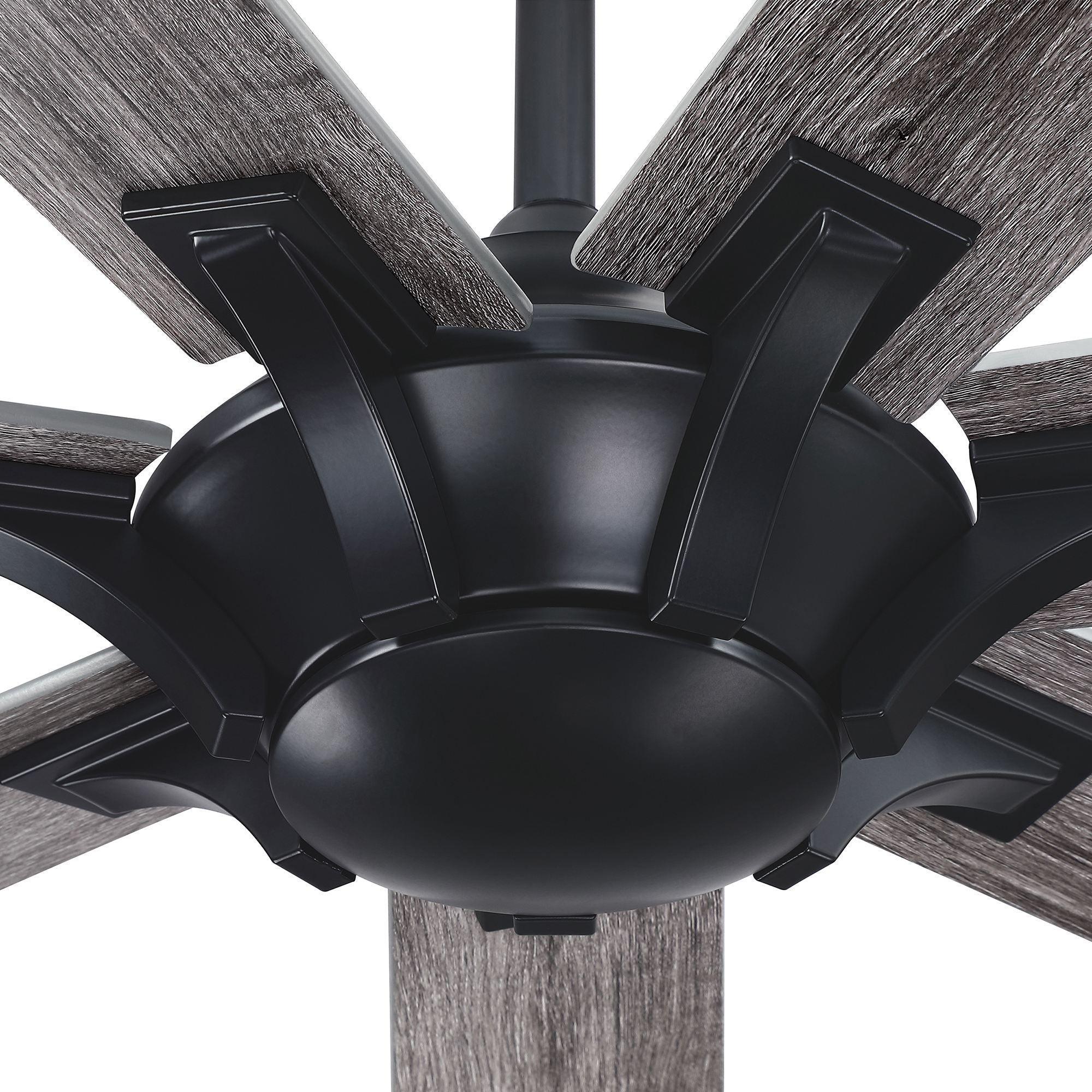 Motor housing close-up of black ceiling fan with gray wood-finish blades