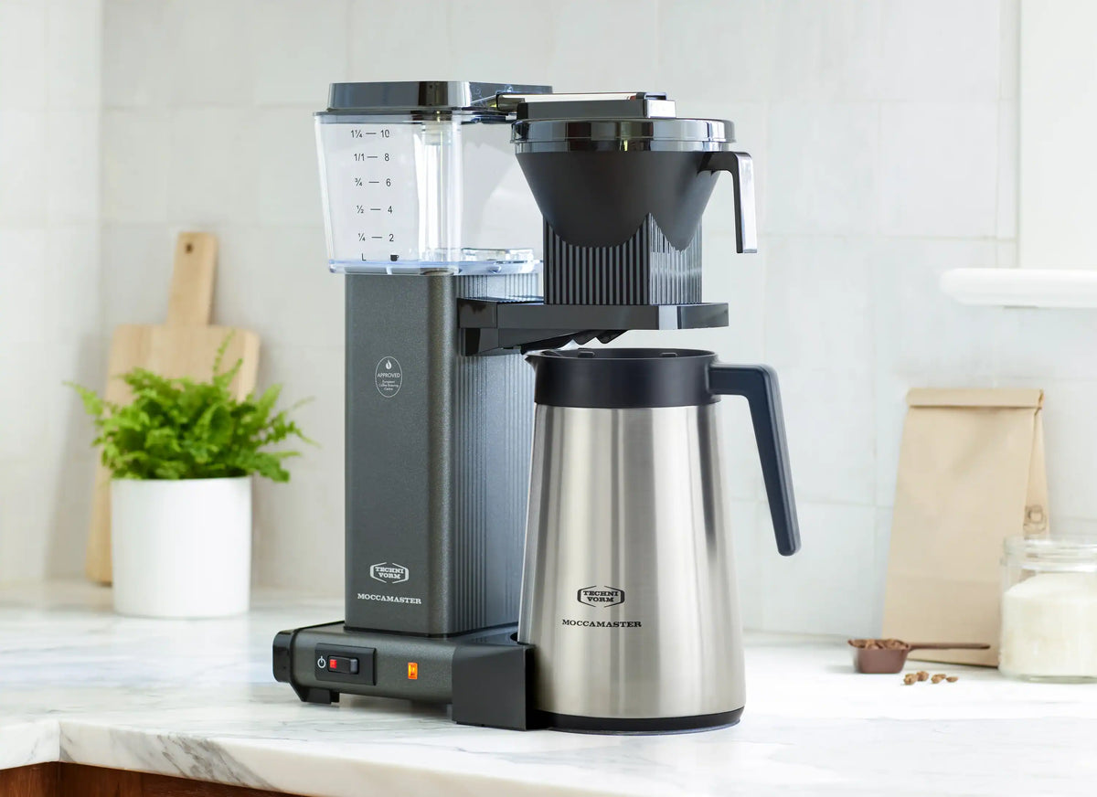 Stone grey coffee maker with black top and thermal stainless carafe on counter