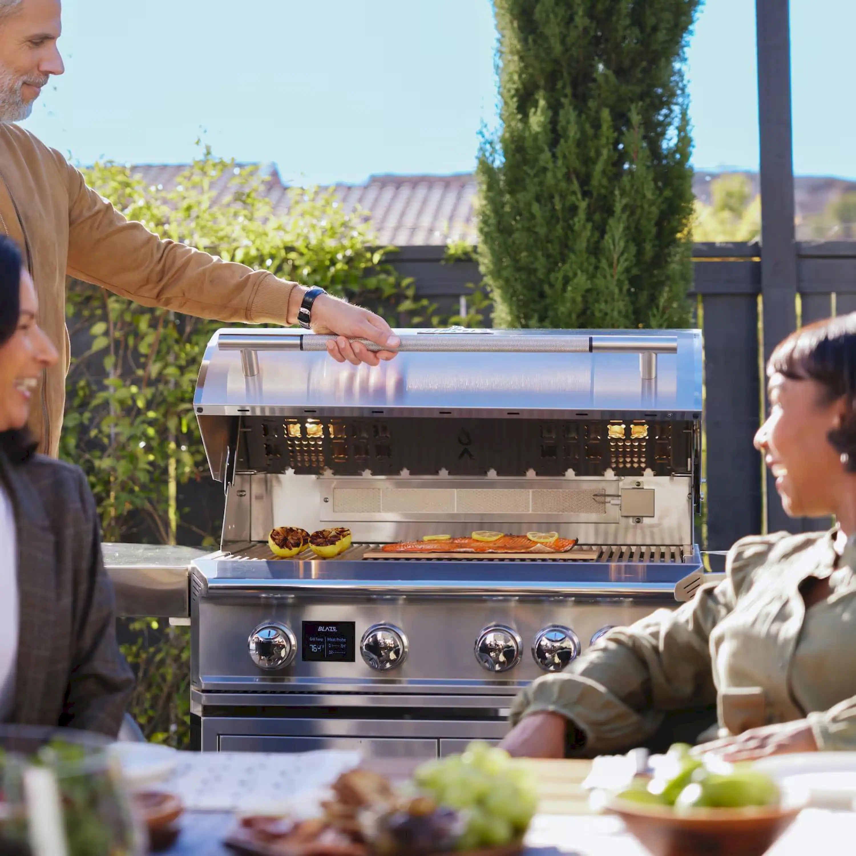 Stainless steel propane grill open with illuminated burners and front control knobs