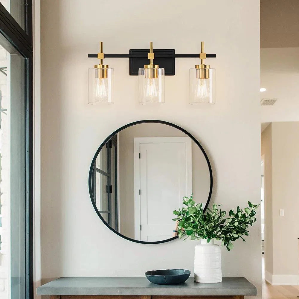 3-light bathroom vanity light with three clear glass shades on black backplate