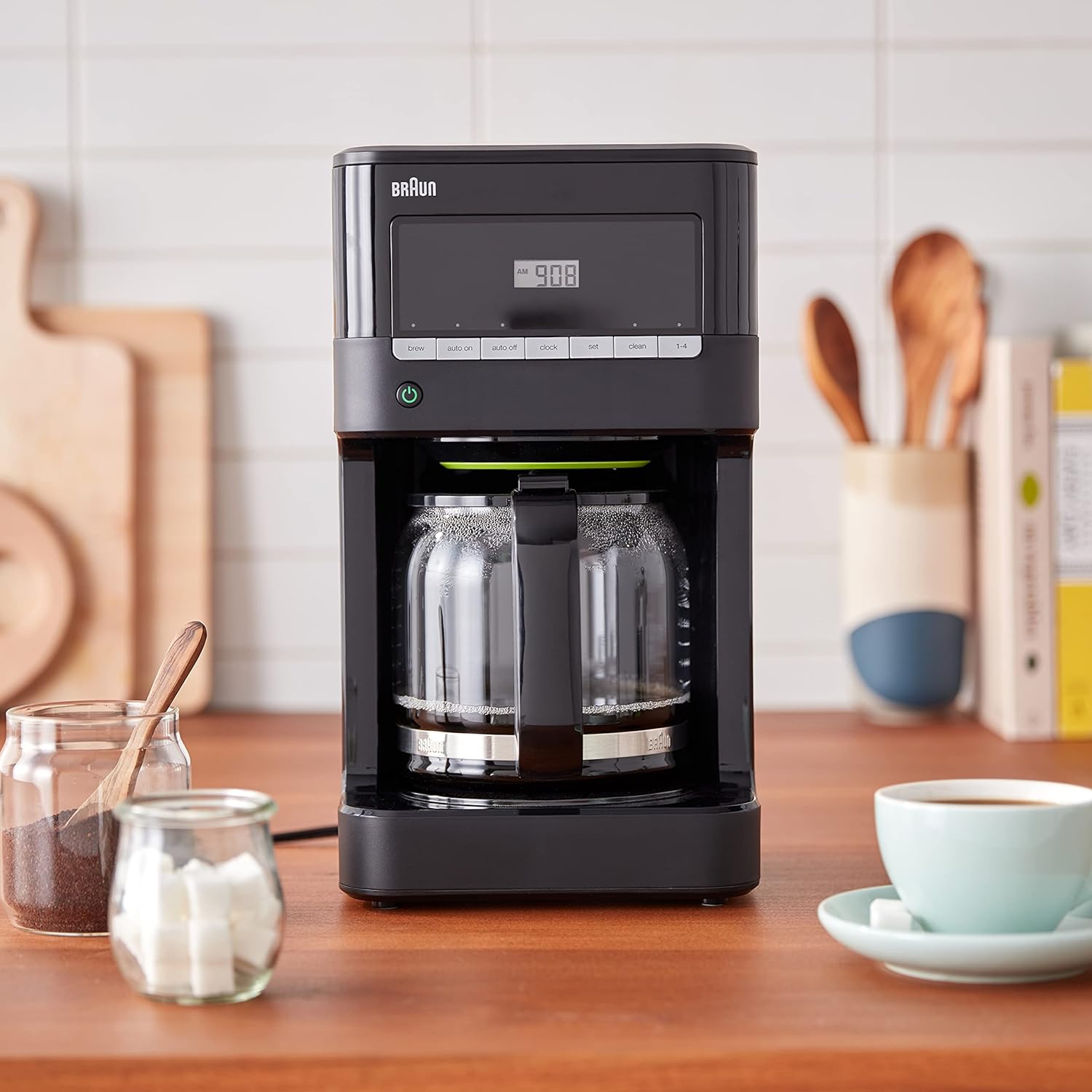 Black Braun 12-cup drip coffee maker on countertop with mugs and glass carafes