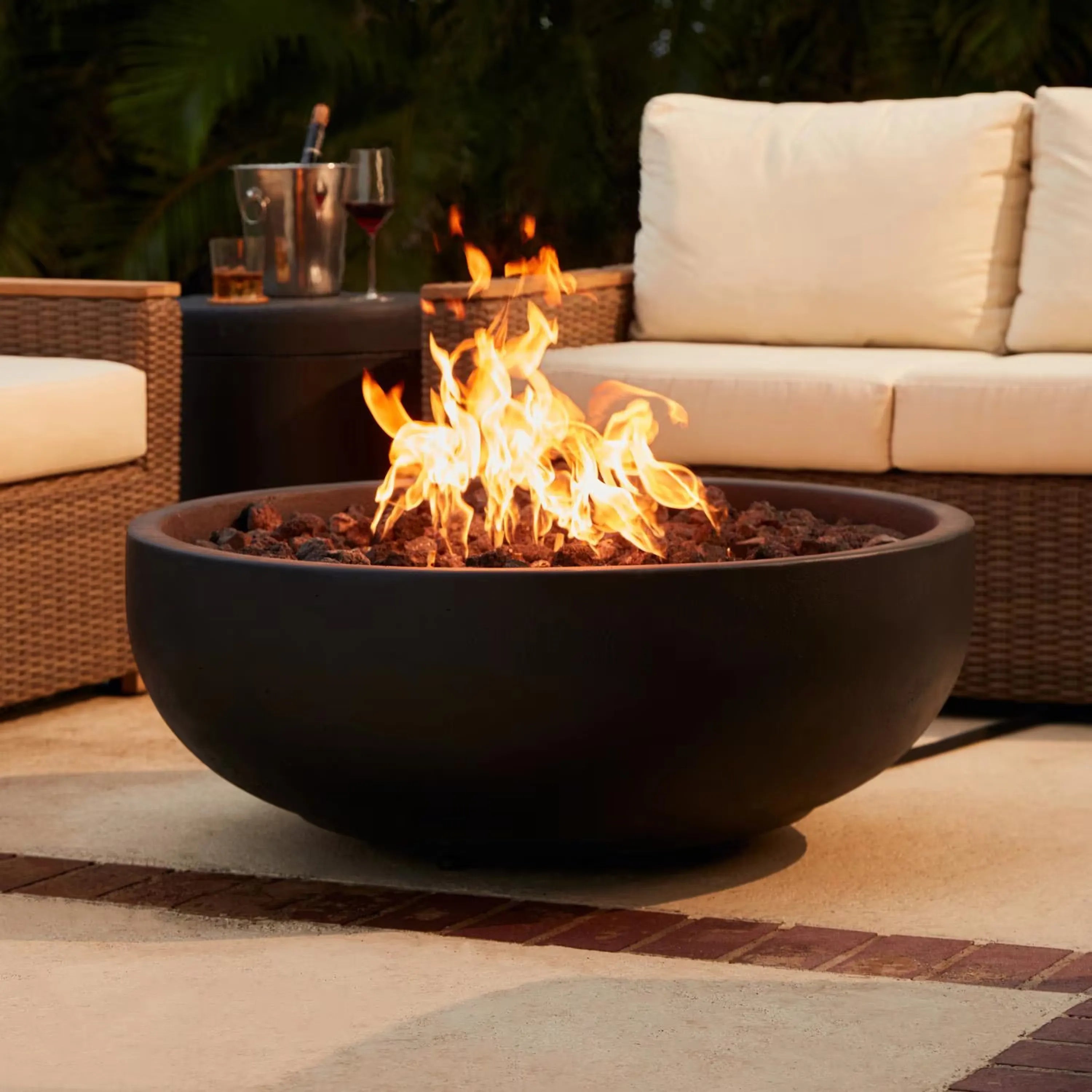 Round concrete propane fire bowl with flames and rock burner insert