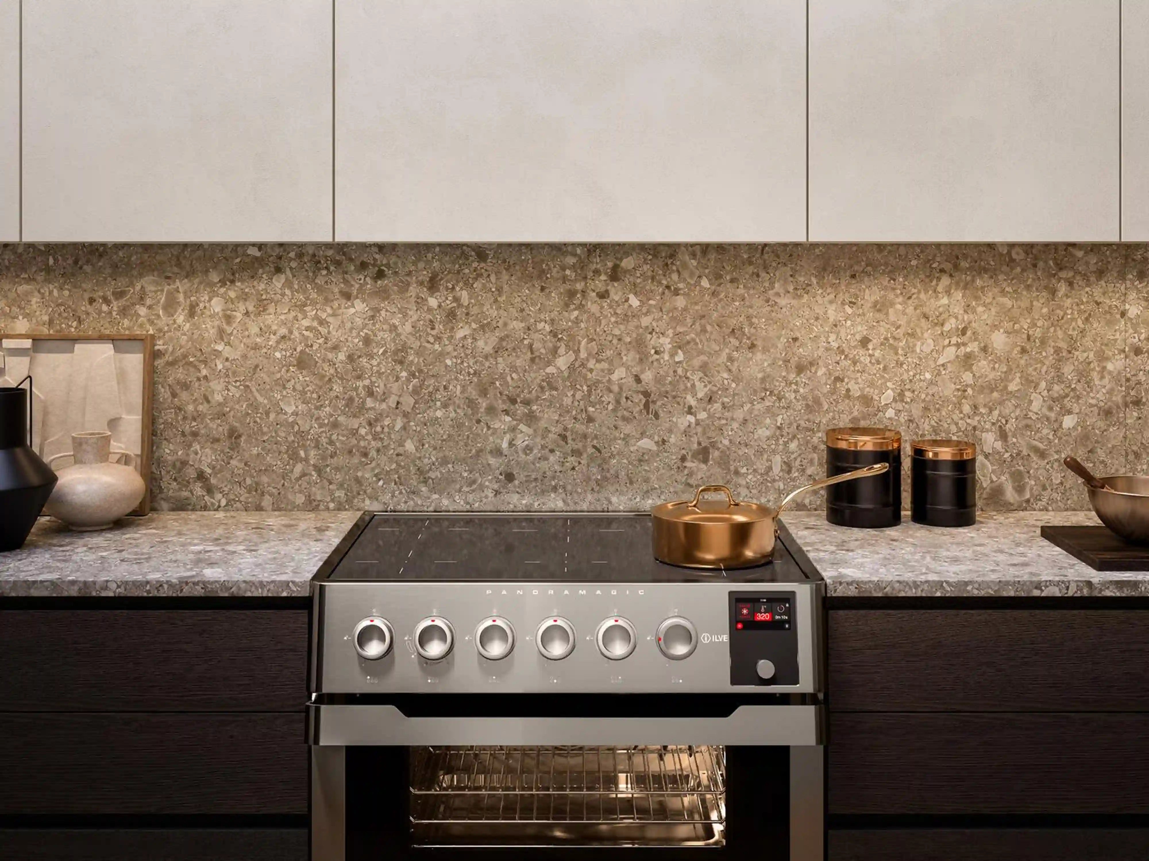 Stainless induction range on countertop with six knob controls and oven door