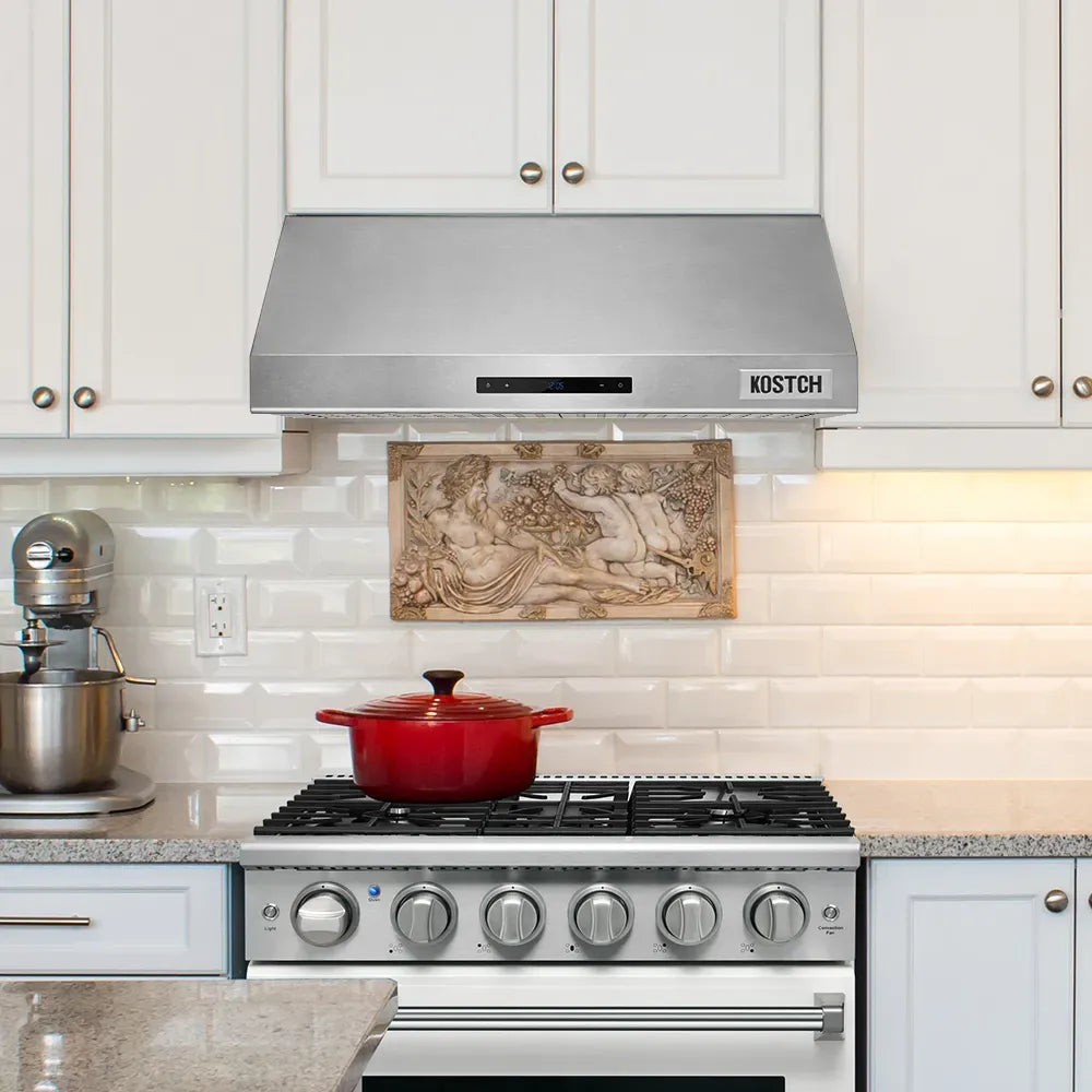 Stainless steel range hood with KOSTCH logo over cooktop and visible control strip