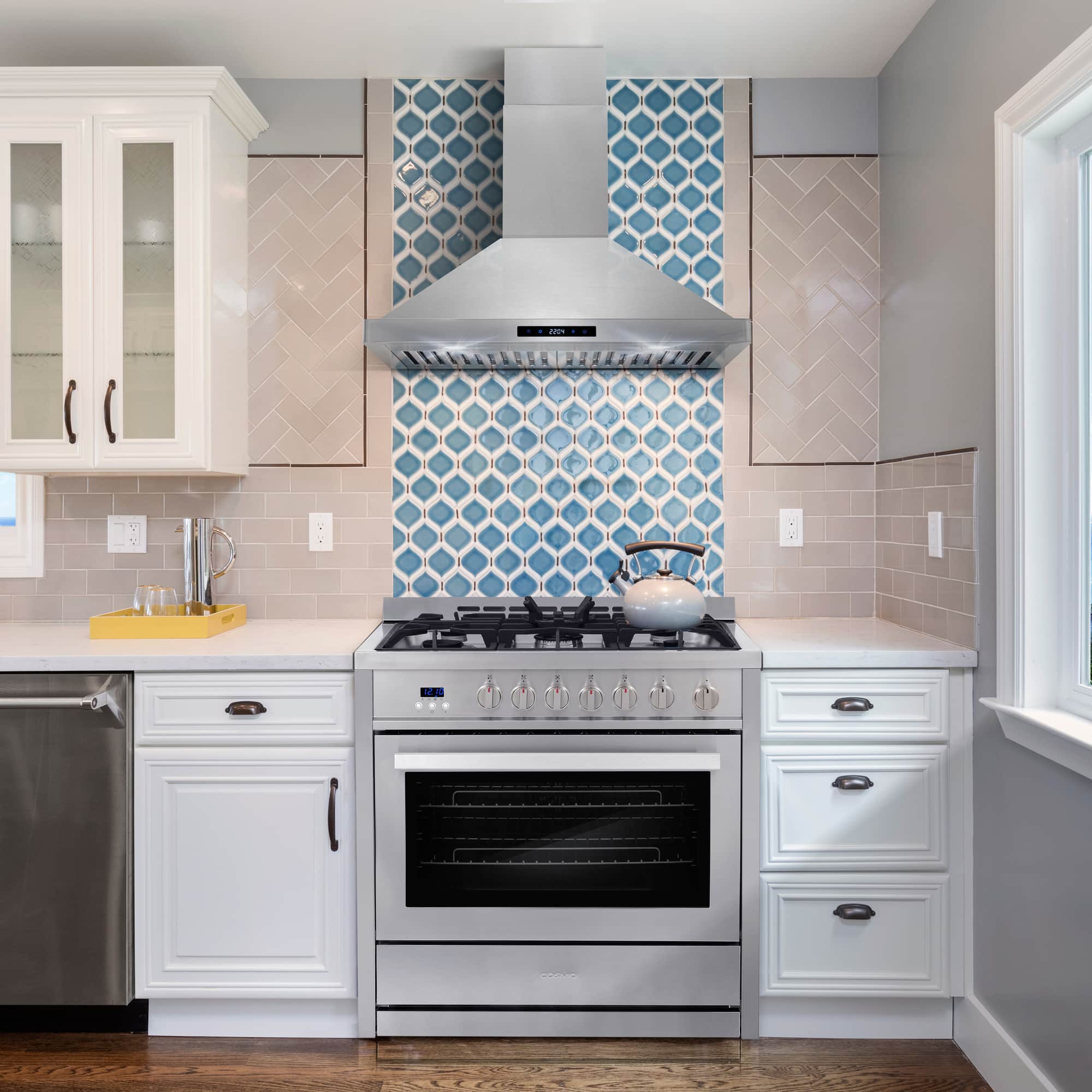 Stainless steel gas range in white kitchen with 5-burner cooktop and oven