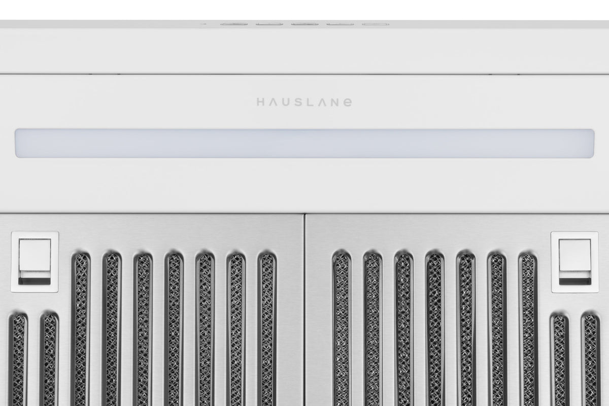 White under-cabinet range hood control area with switches and vent grille openings