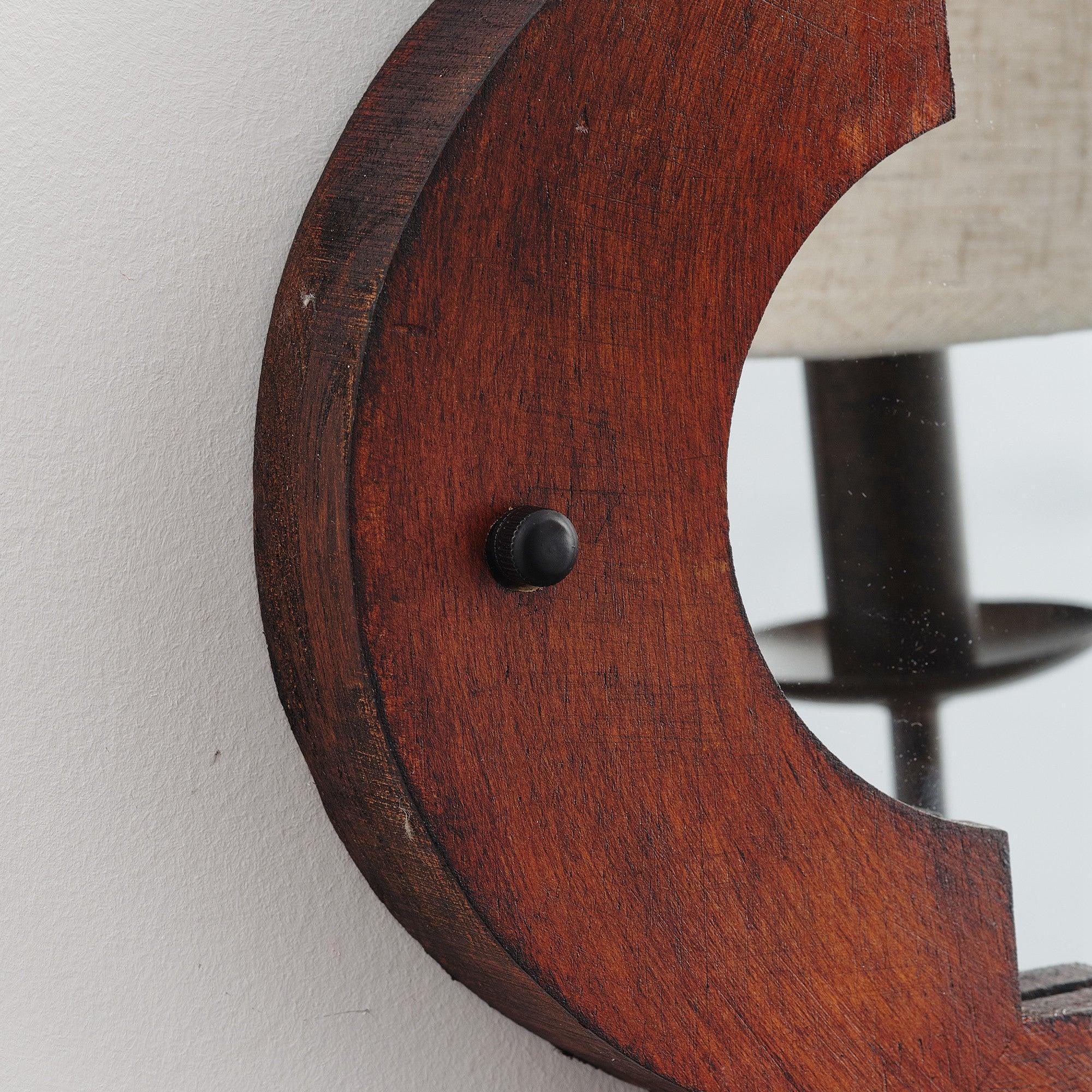 Close-up of brown rustic wood wall sconce with round black mounting hardware