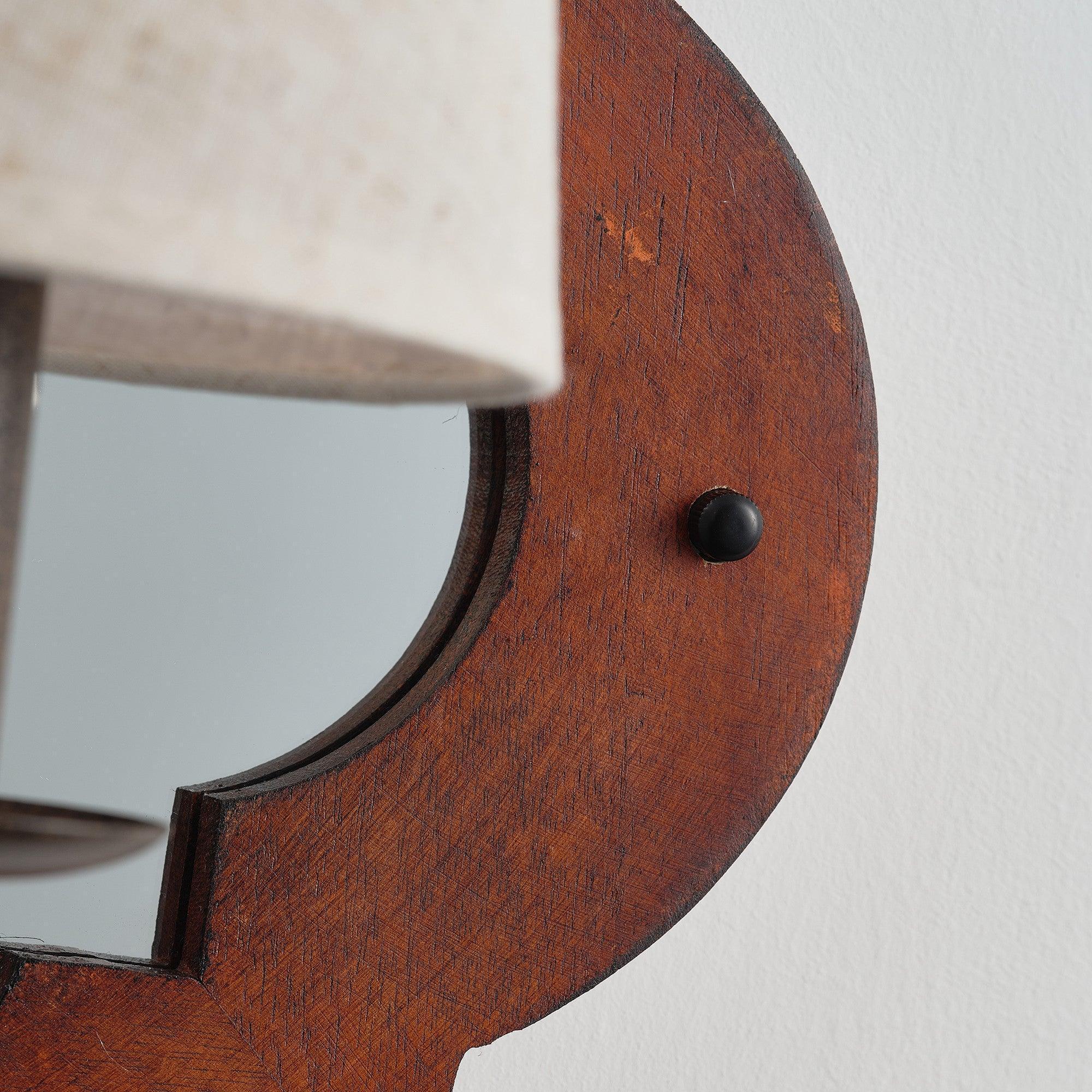 Close-up of brown wood wall sconce with textured finish and round black mounting knob
