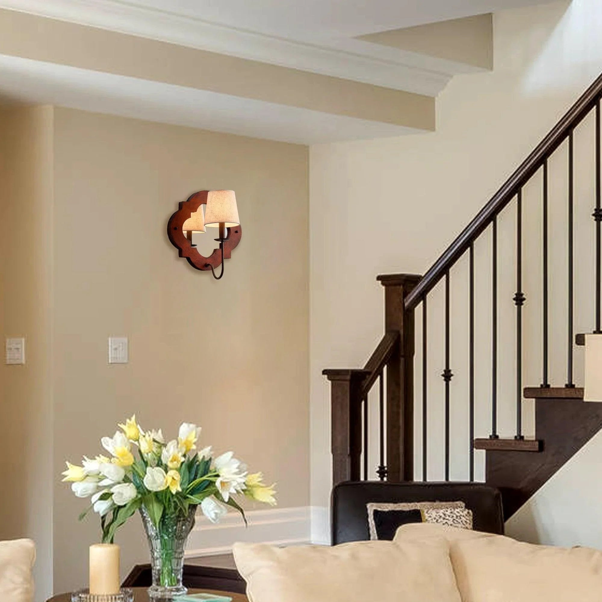 Brown rustic wall sconce with two fabric shades mounted on a wall near a staircase