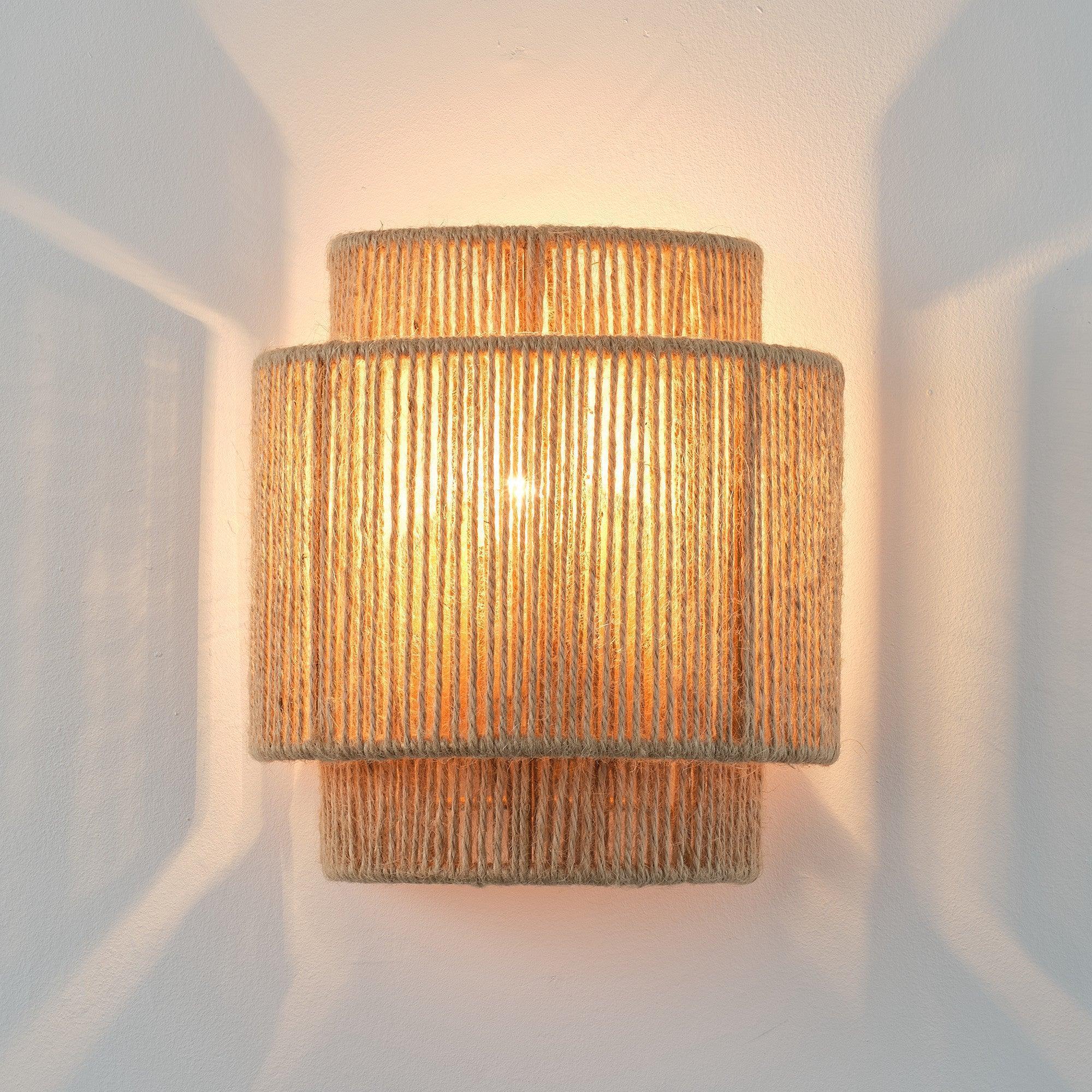 Brown rattan 1-light wall sconce with warm glow through woven shade