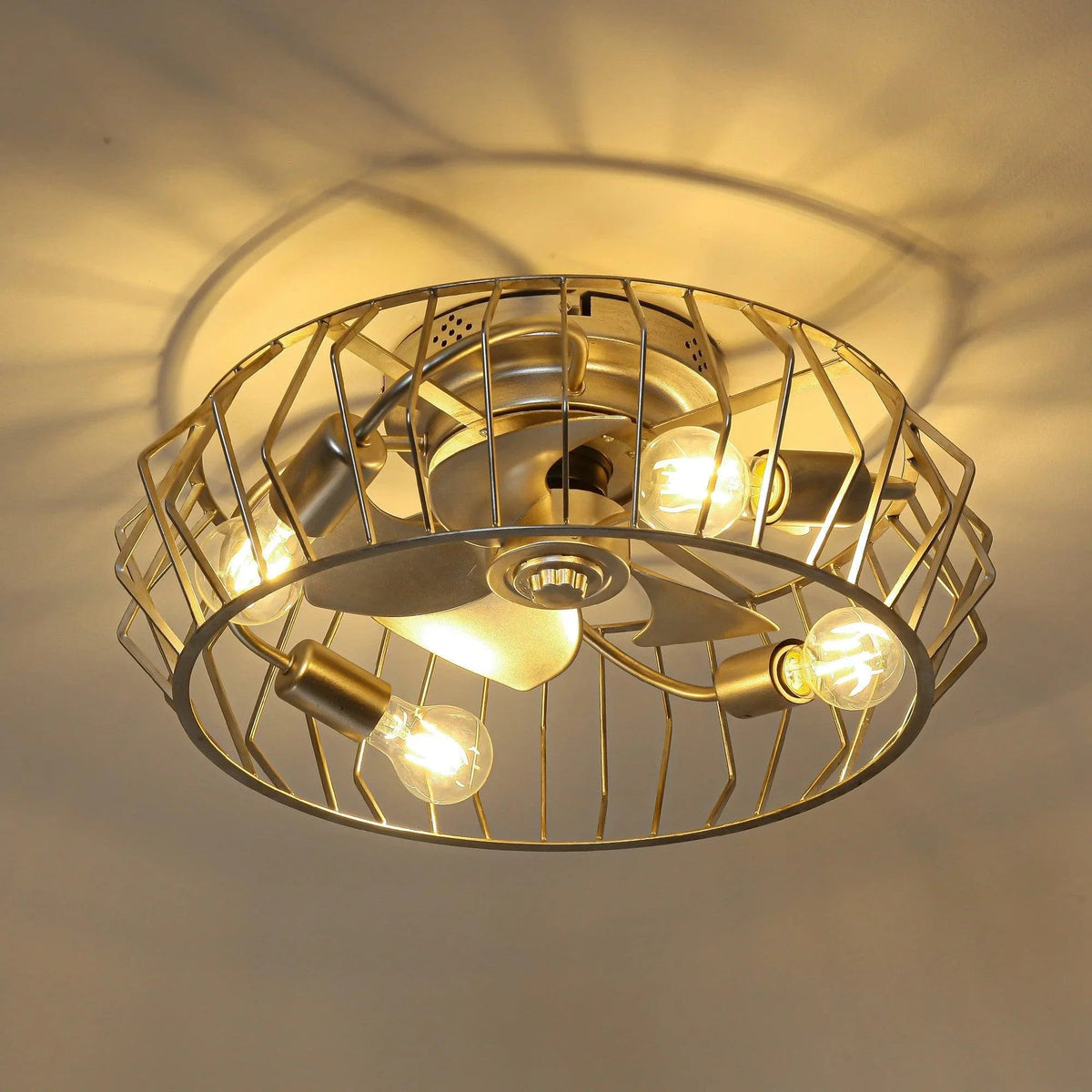 Silver ceiling fan with light showing wire cage and four glowing bulbs