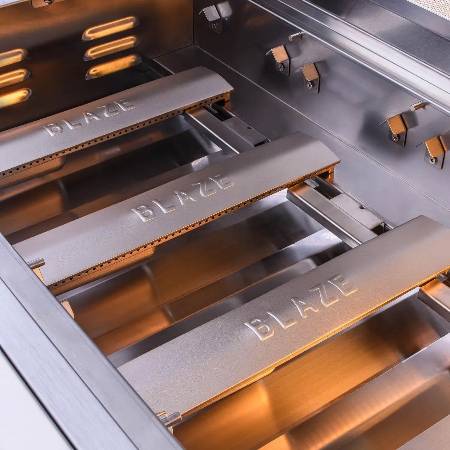 Open propane grill firebox with metal grates and Blaze branding on panels