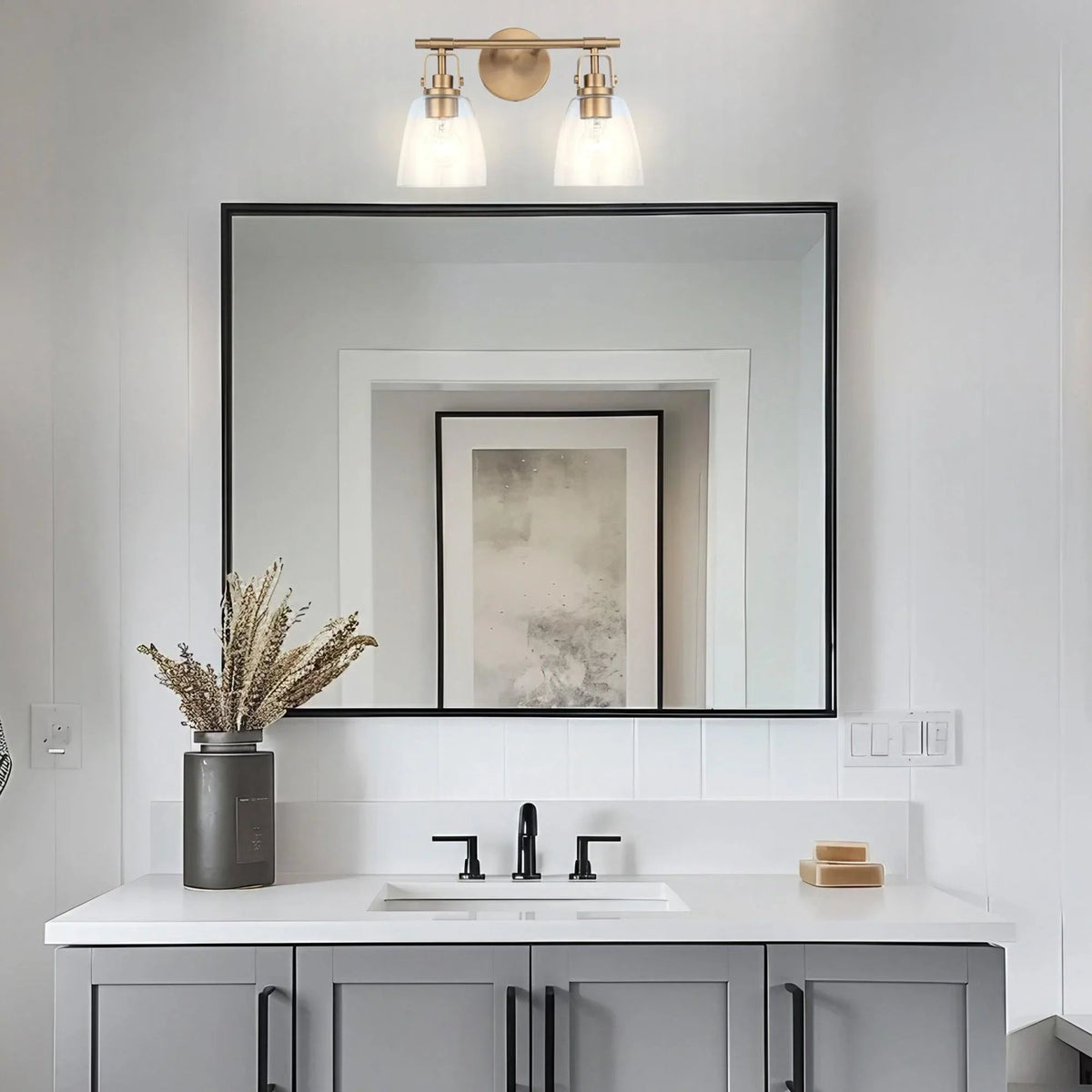 Golden 2-light vanity light with two frosted glass shades and circular backplate.