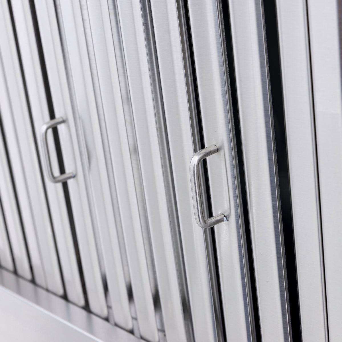 Close-up of stainless steel vent hood grille bars with mounting handles