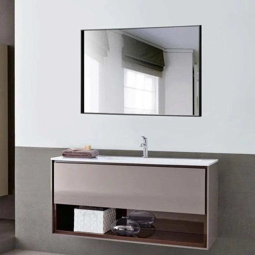 Black framed wall mirror with reflective glass mounted above a white vanity