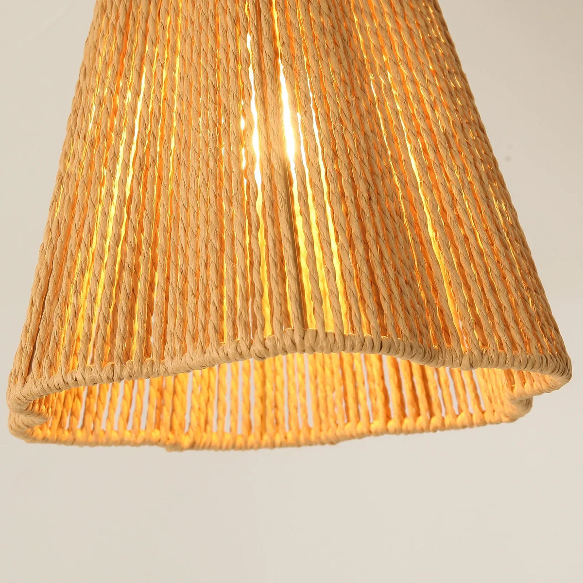 Close-up of jute-wrapped drum lampshade with open-weave bottom on golden fixture
