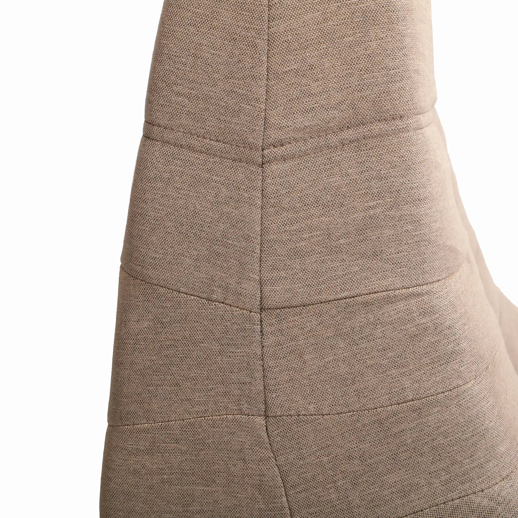 Side view of taupe-brown compressed foam armchair with padded panel seams