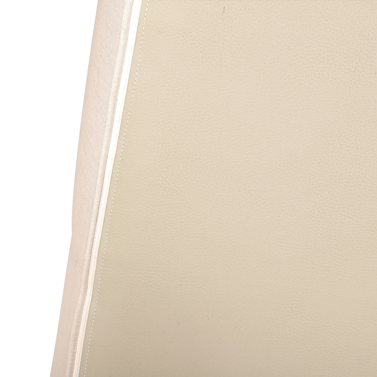 Beige upholstery fabric close-up with stitched trim along chair edge