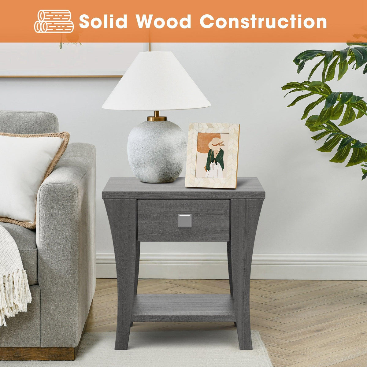 Gray end table styled with decor; single drawer with silver pull and open shelf.
