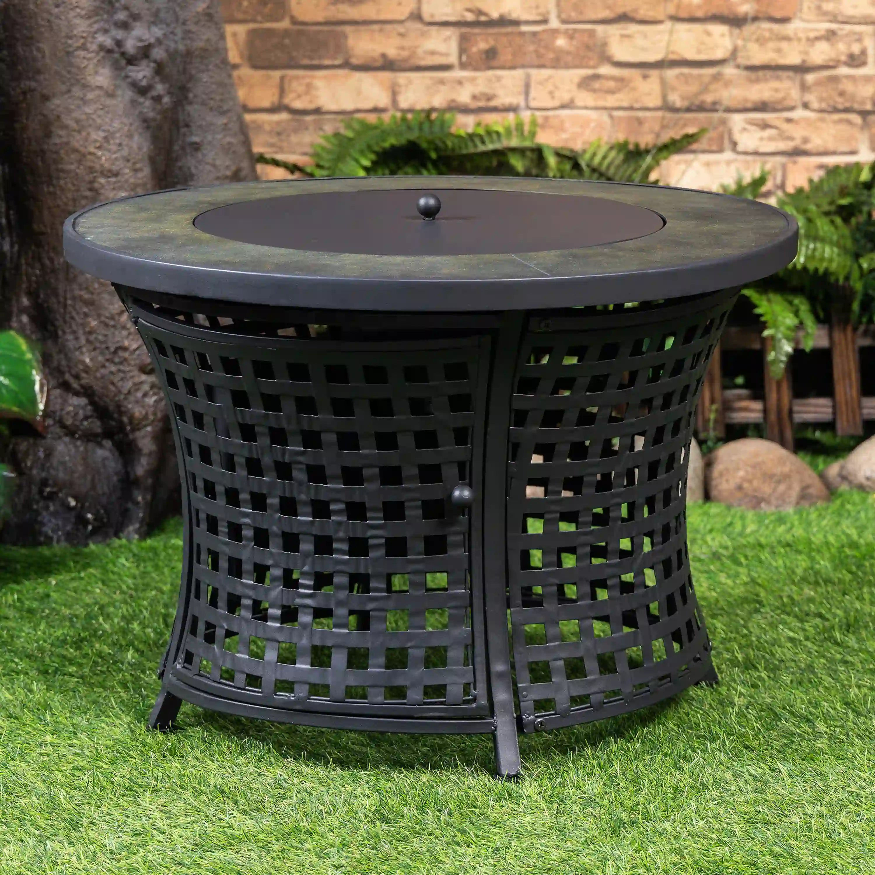 Black round outdoor propane fire pit table with mesh sides and circular lid
