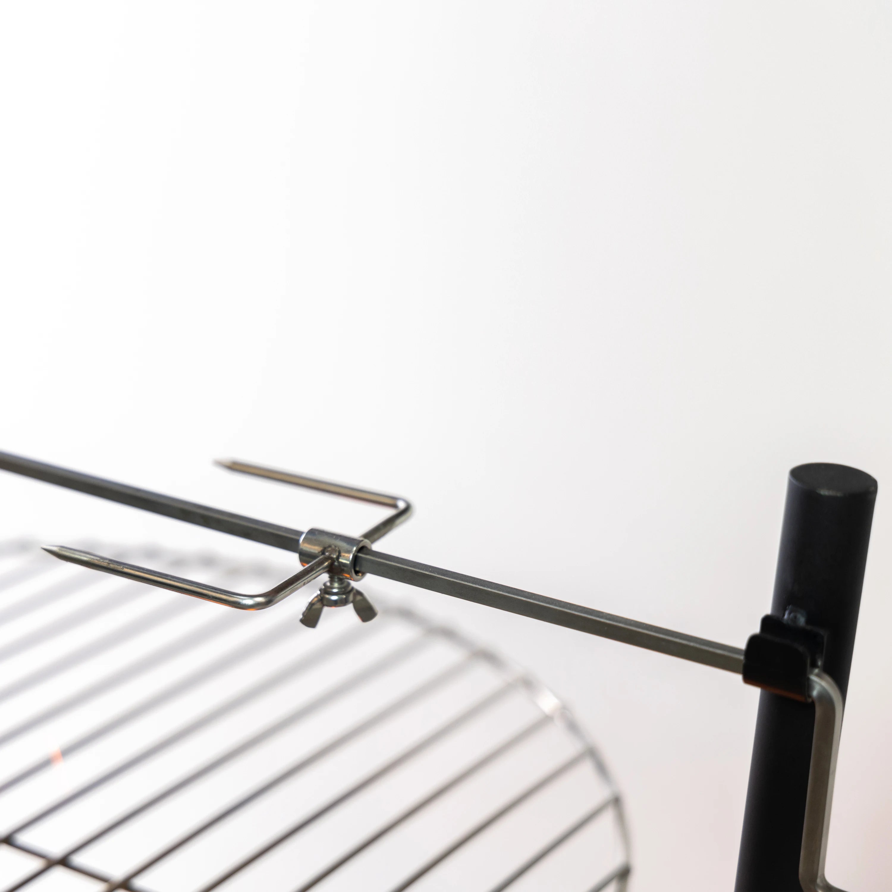 Rotisserie rod assembly with metal prongs mounted on the grill frame