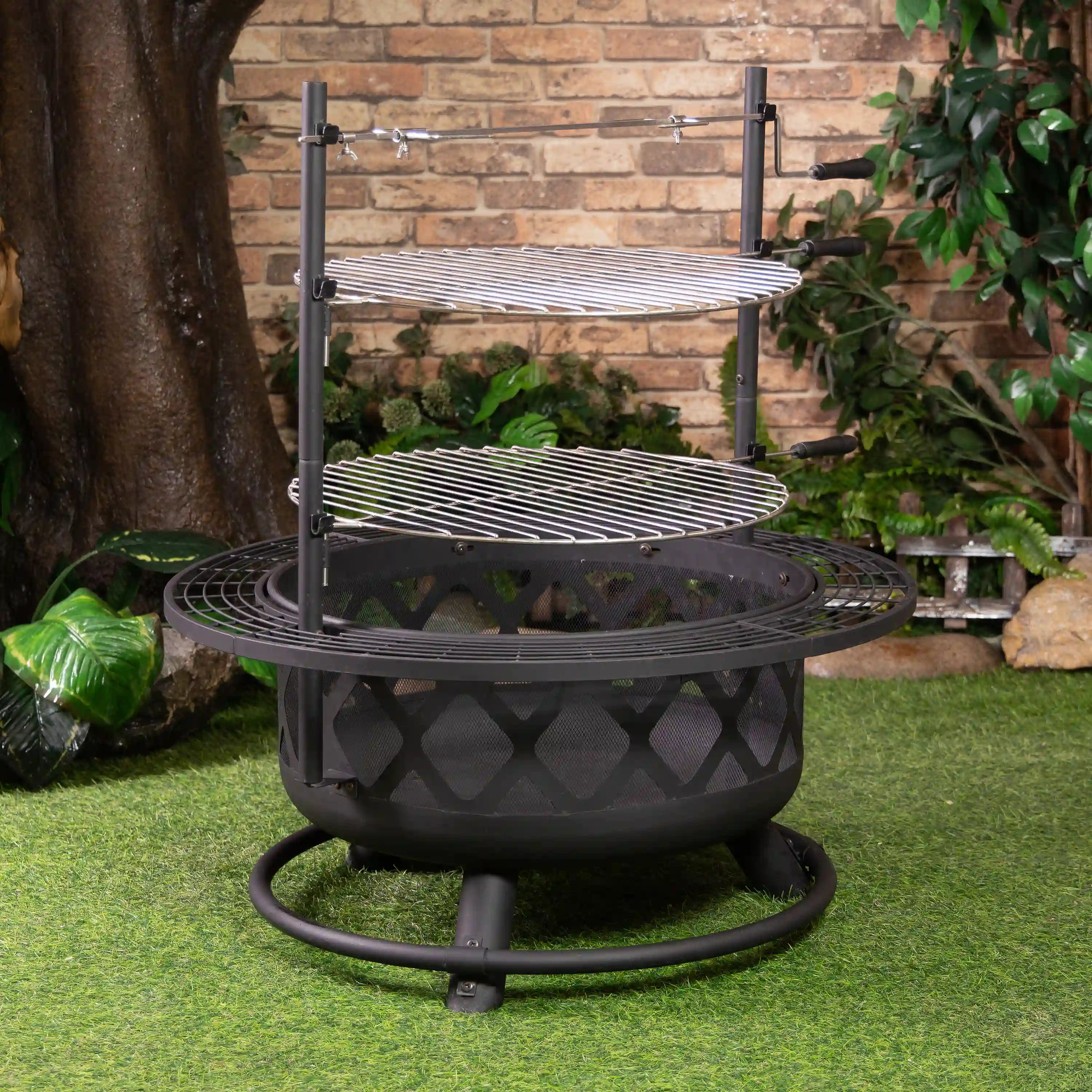 Outdoor steel fire pit grill with two stacked cooking grates and rotisserie frame