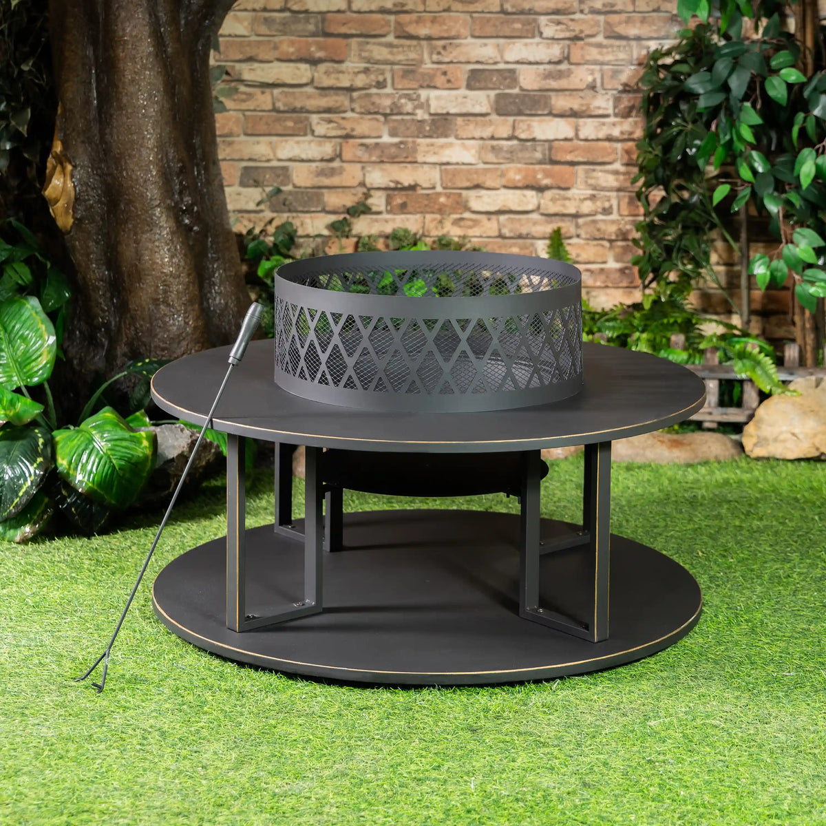 Outdoor steel fire pit with round base, open log compartment, mesh fire bowl.