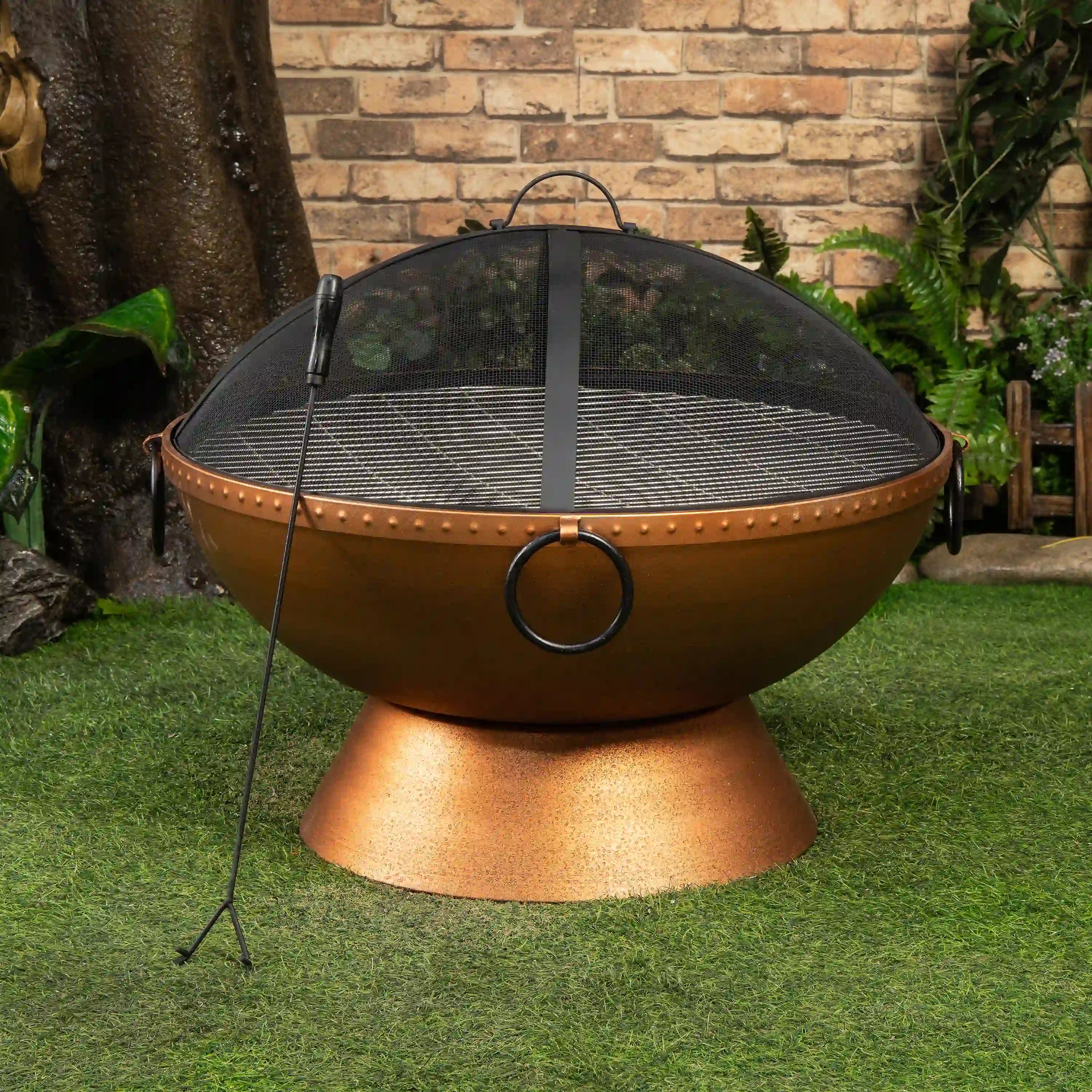 Round firepit with mesh spark screen and side handles, centered on a metal base