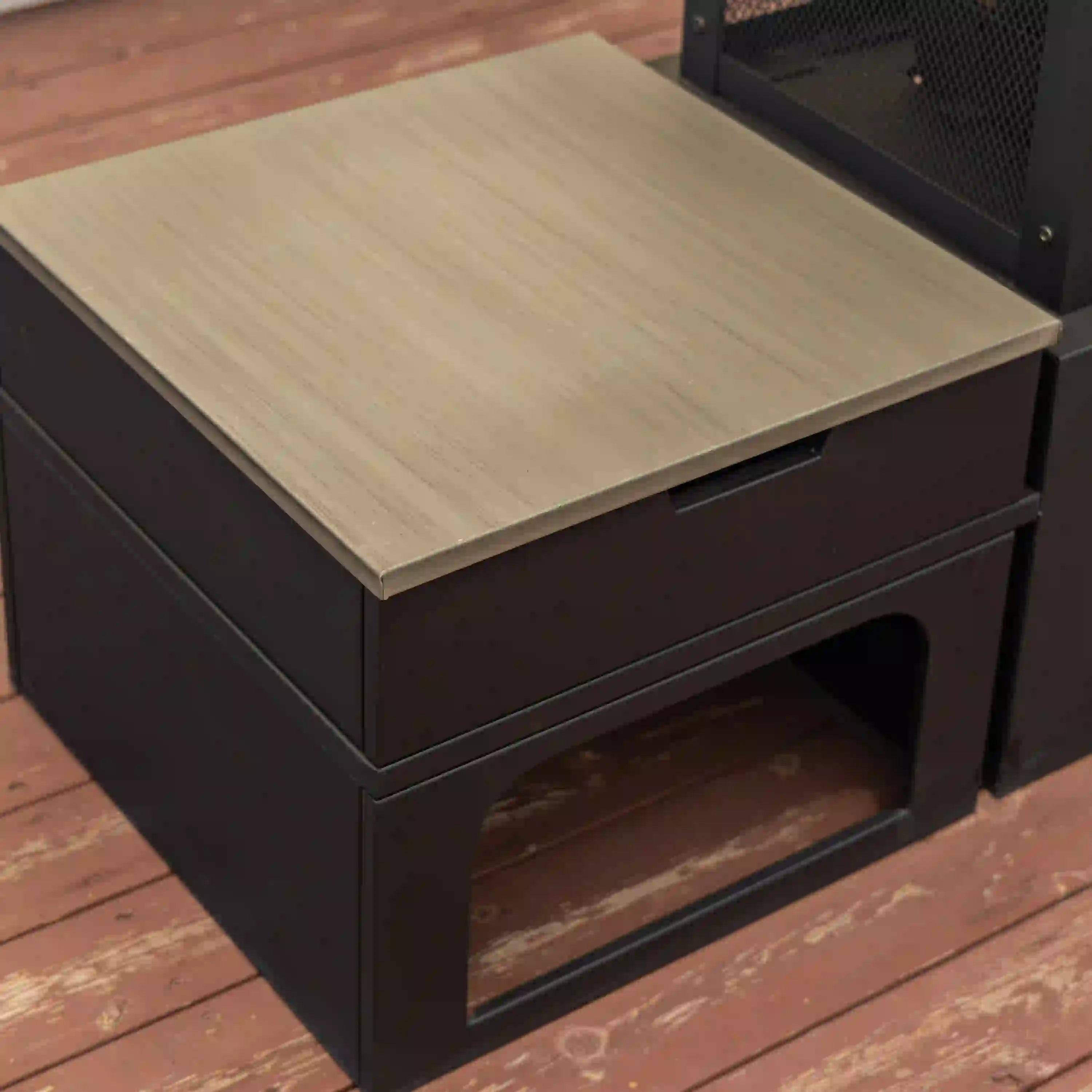 Square side table top on black outdoor fireplace cabinet with storage opening