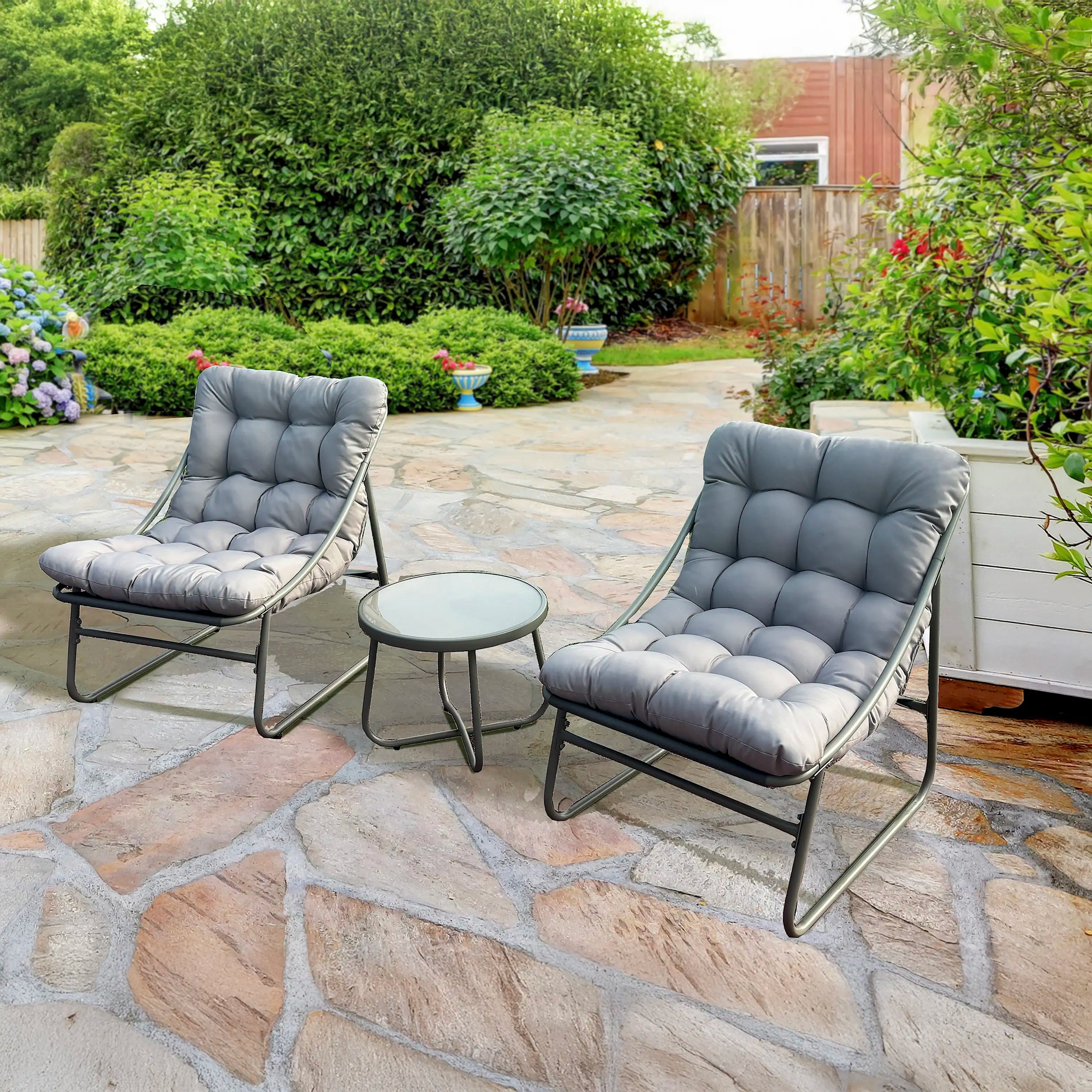 Outdoor bistro set with two gray-blue chairs and round coffee table on stone patio