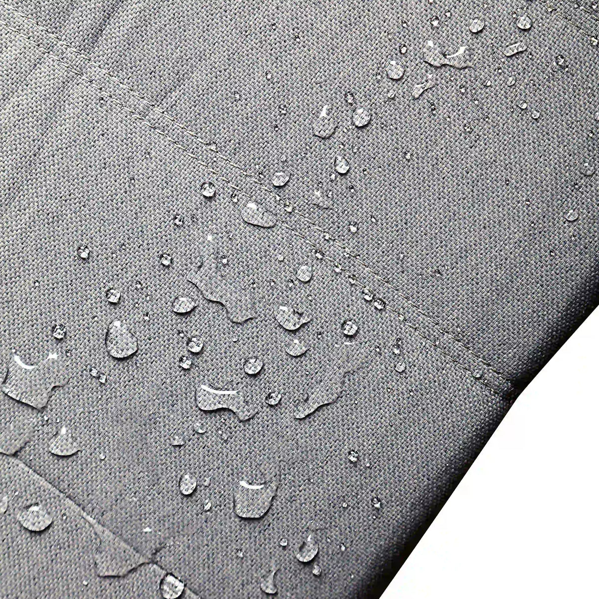 Gray outdoor cushion fabric with water droplets and textured woven surface