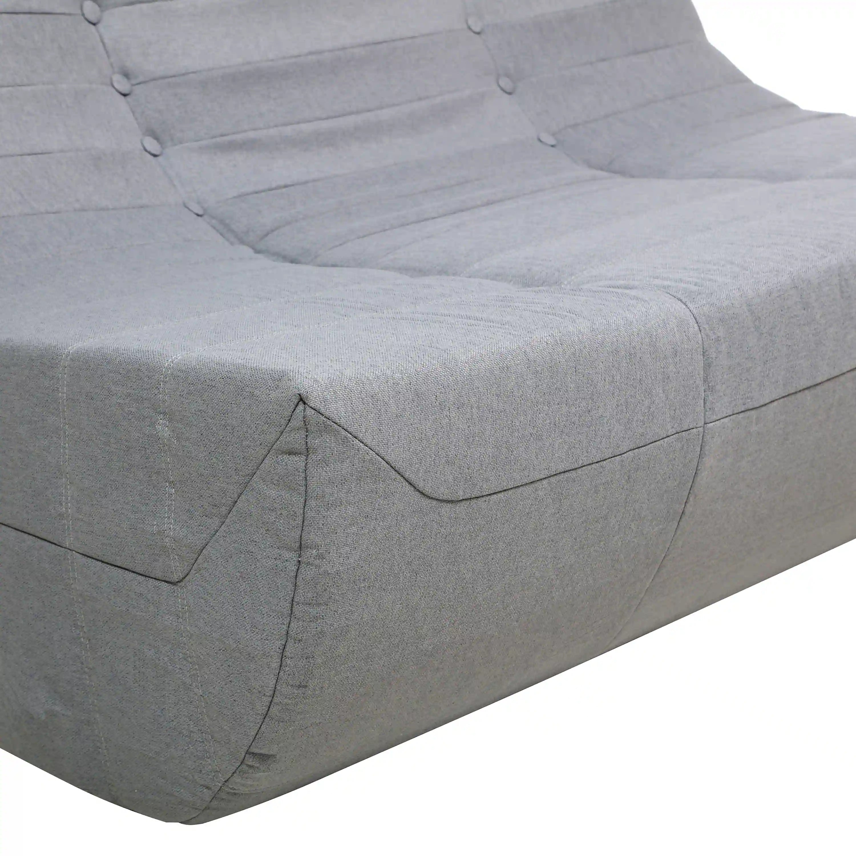 Gray outdoor loveseat-style cushion with tufted buttons and curved armrest