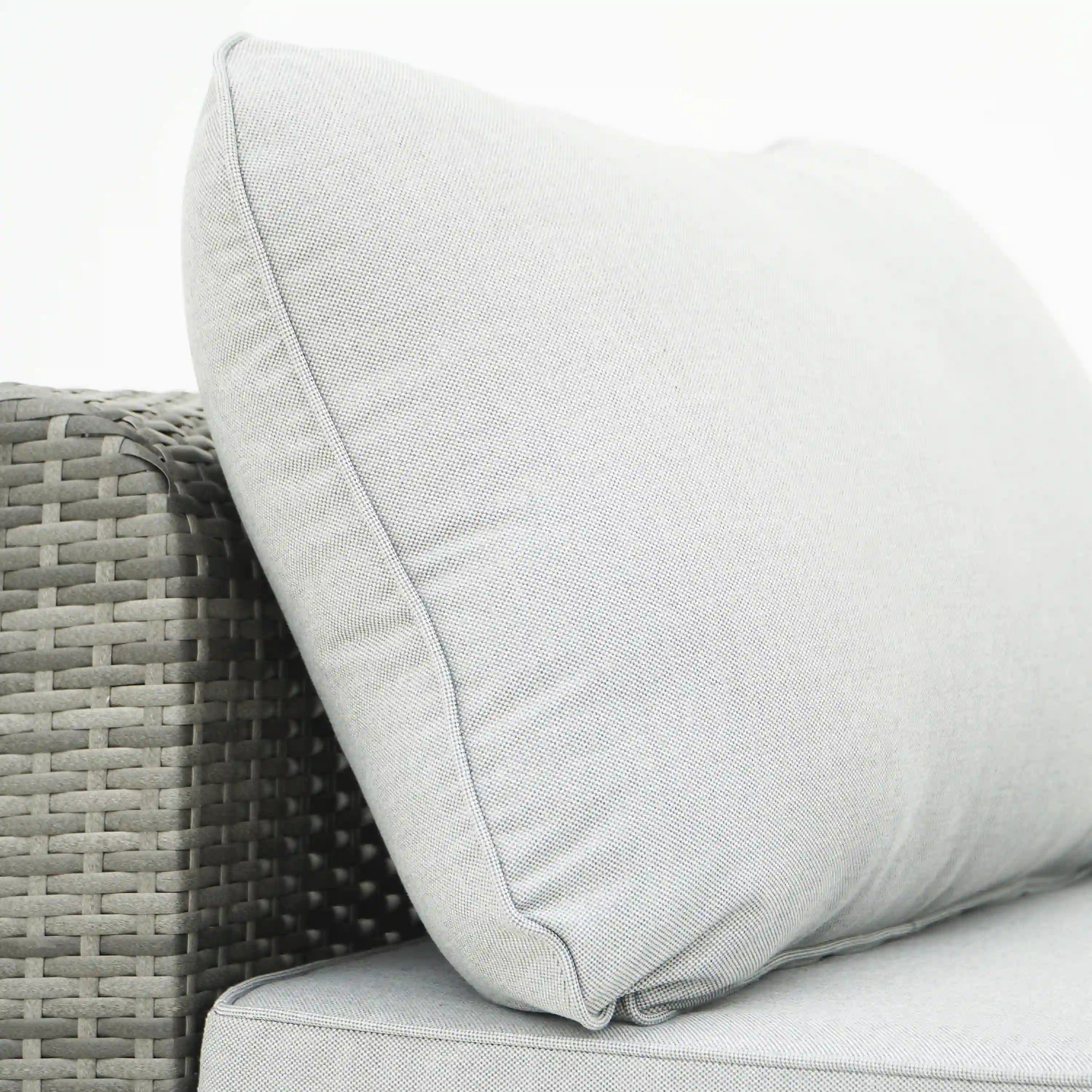 Gray outdoor sectional sofa cushion with welt seam on wicker arm
