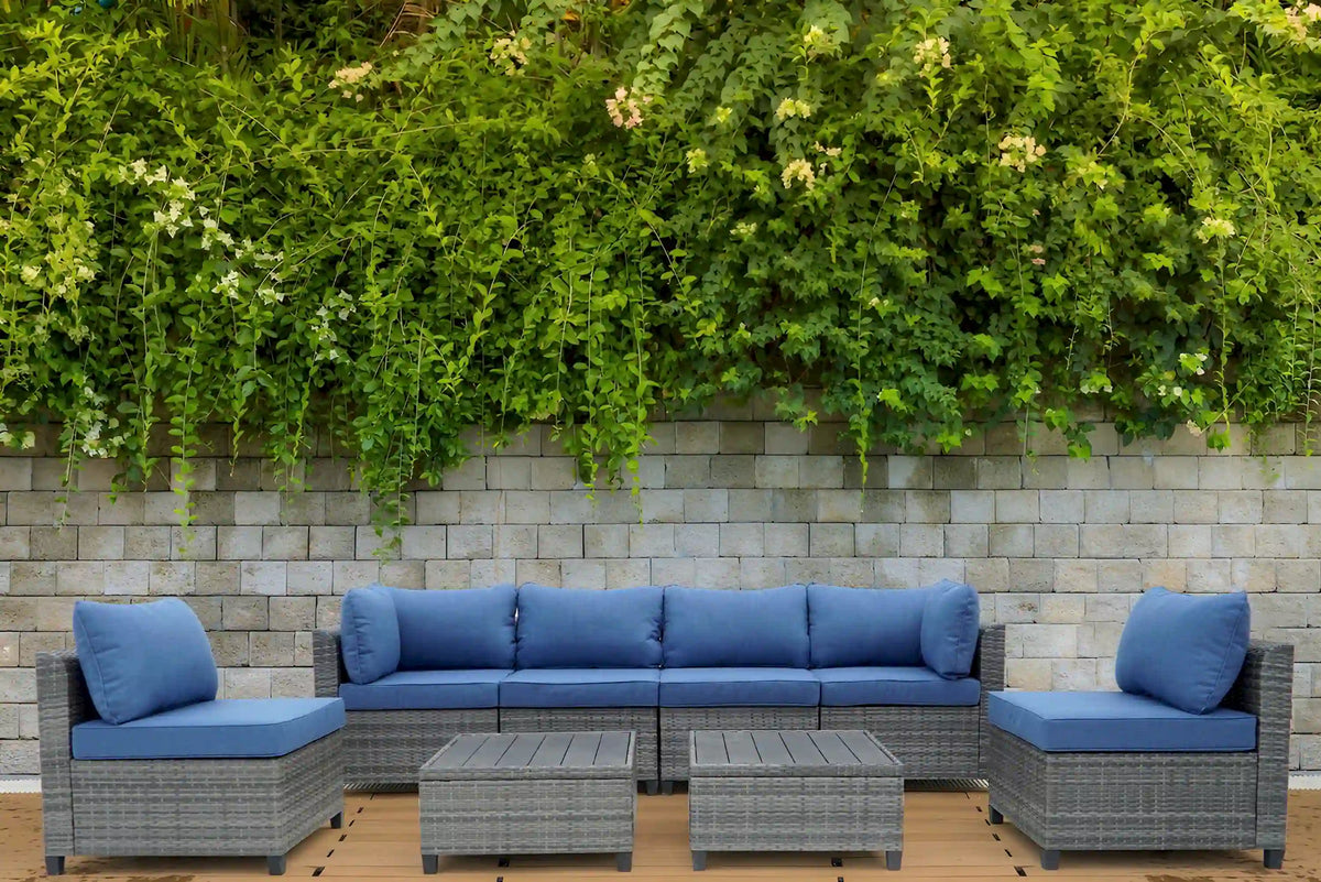 Gray outdoor sectional sofa set with blue cushions and matching side tables