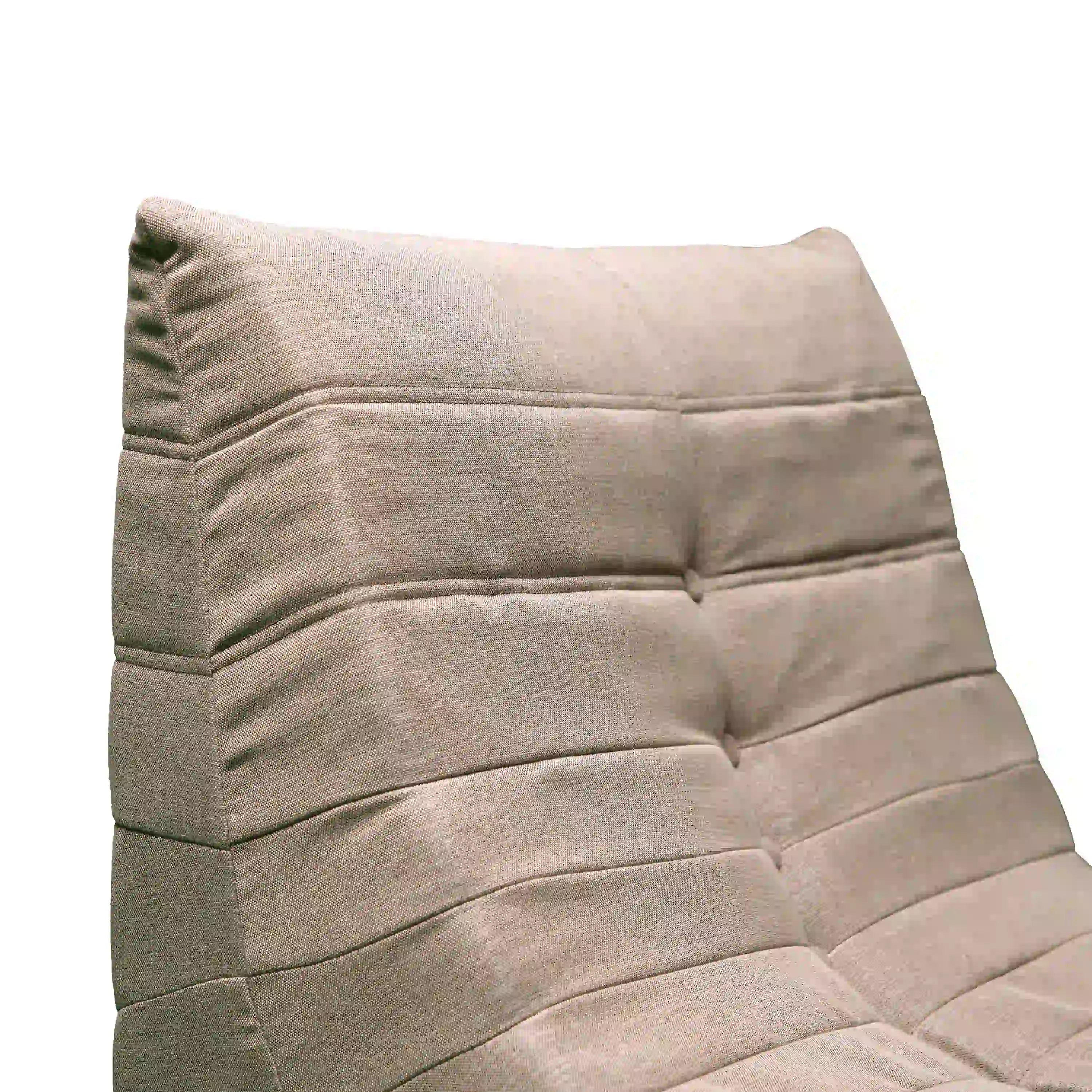 Close-up of tan compressed foam loveseat cushion with stitched horizontal seams.